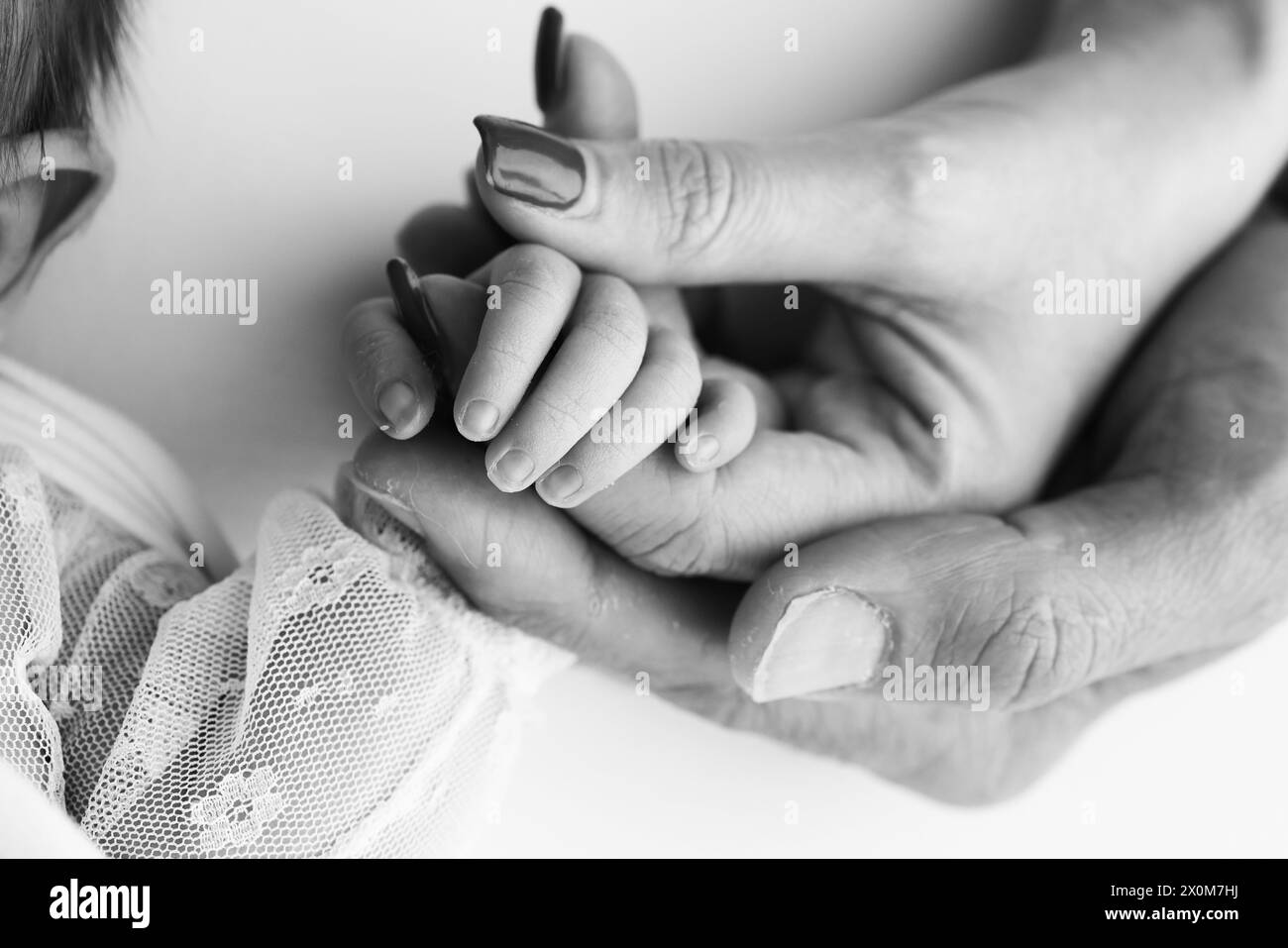 Das neugeborene Baby hat nach der Geburt einen festen Griff am Finger der Eltern. Stockfoto