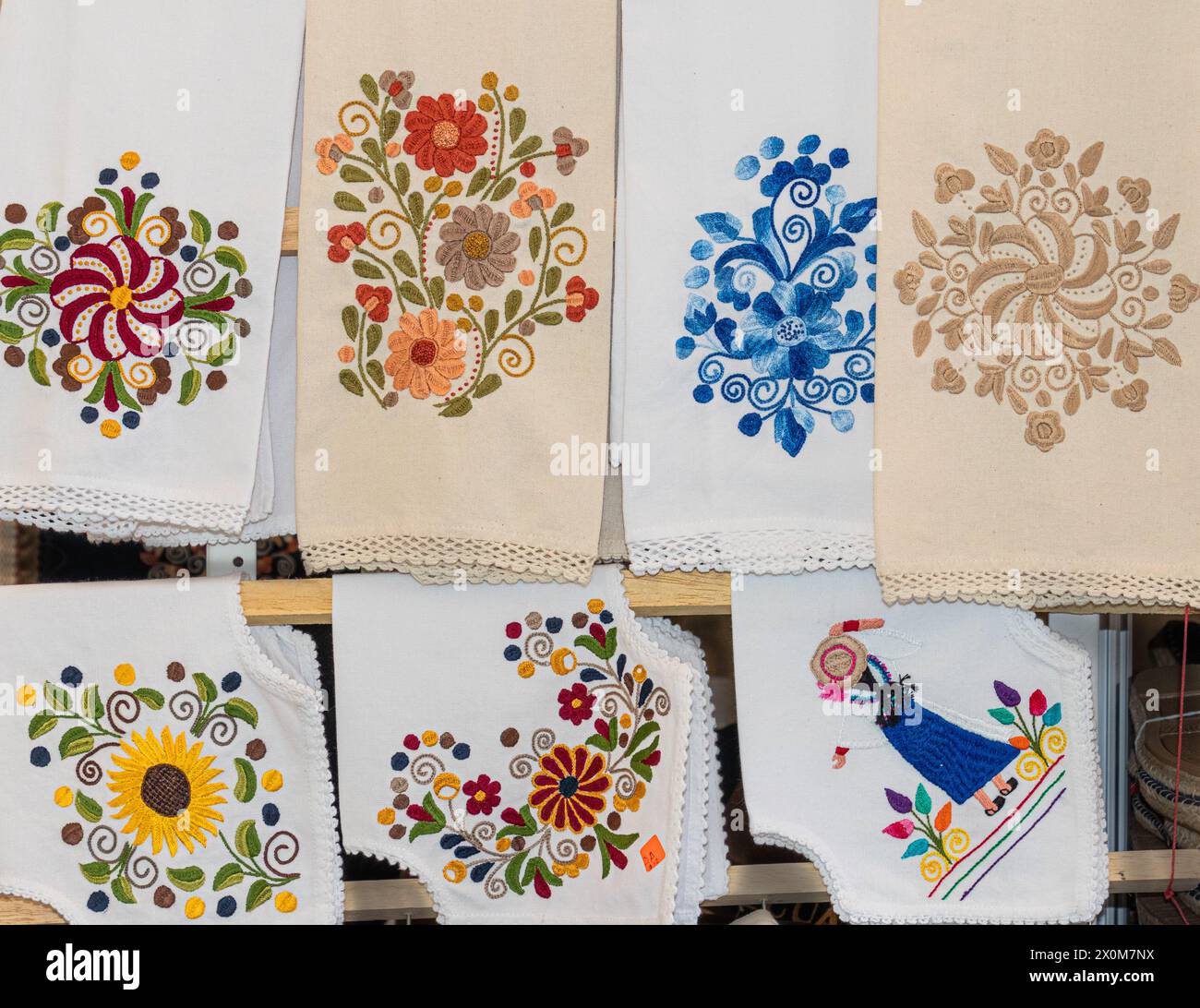 Gestickte Deckchen, Servietten und Tischläufer mit Blumen und ethnischem Design auf dem offenen Markt in Ecuador, Cuenca. Beliebte Souvenirs Stockfoto