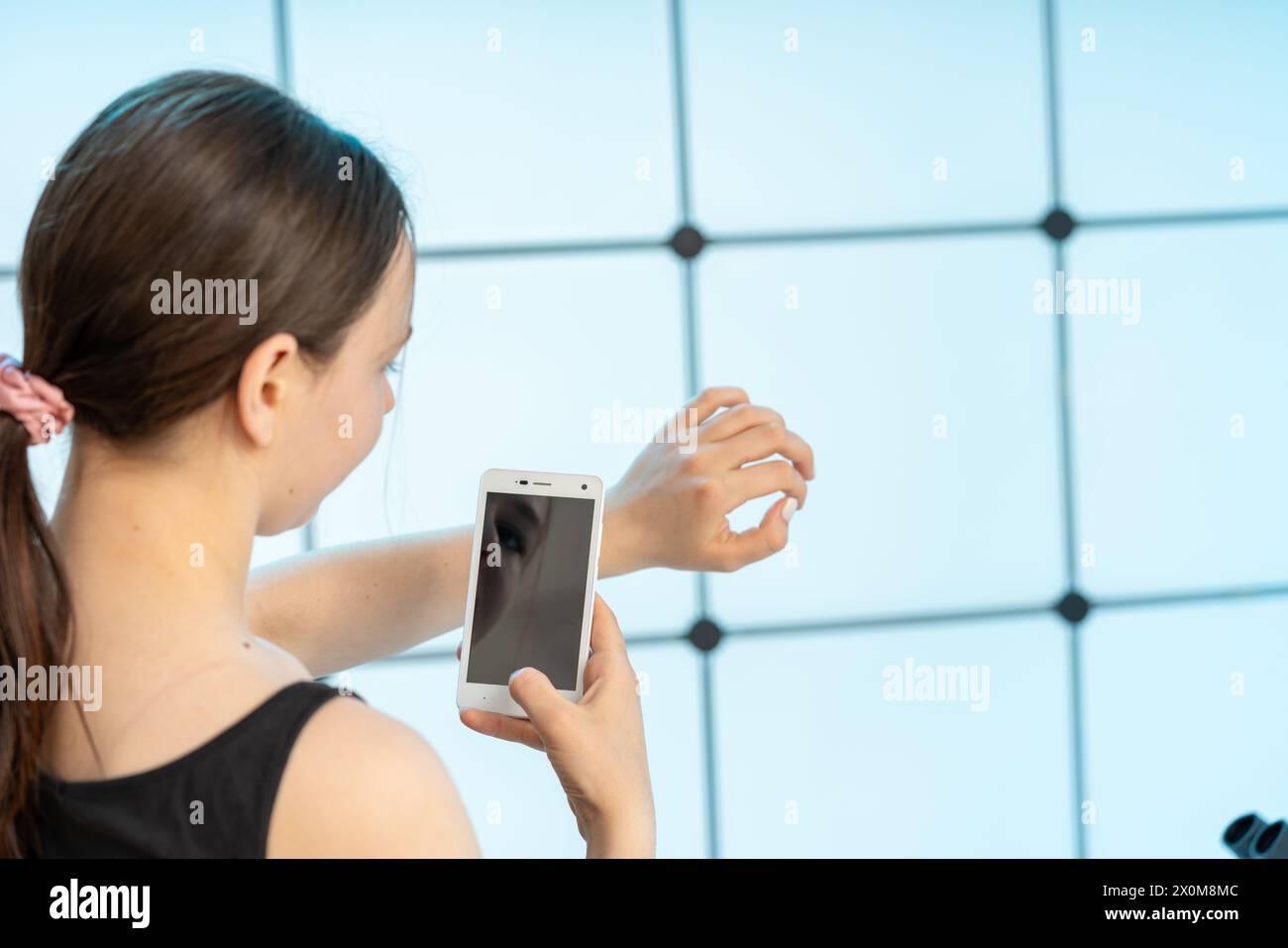 Frau, die ein Smartphone benutzt, um die Haut zu überprüfen. Stockfoto