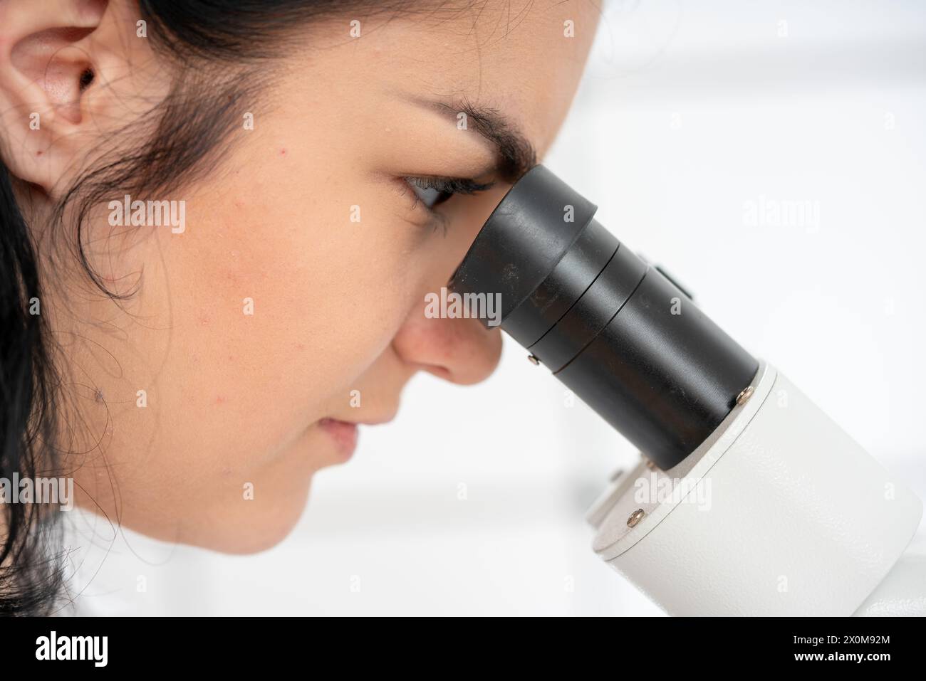Wissenschaftler, der durch ein Mikroskop schaut. Stockfoto