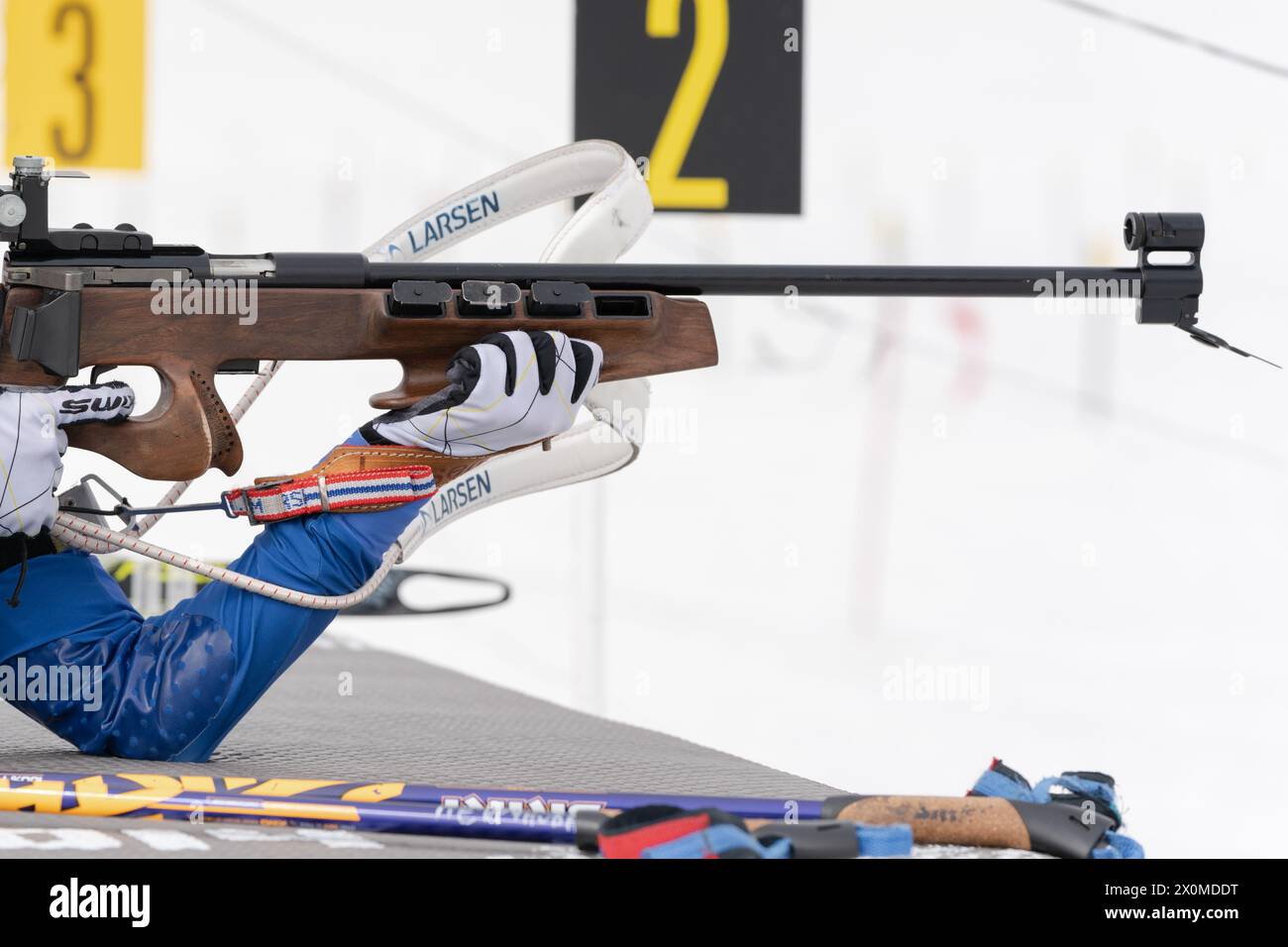 Sportlerbiathletin-Gewehrschießen in Bauchlage. Selektiver Fokus, extreme Nahaufnahme. Biathlet im Schießstand. Junior-Biathlon-Wettkampf Stockfoto