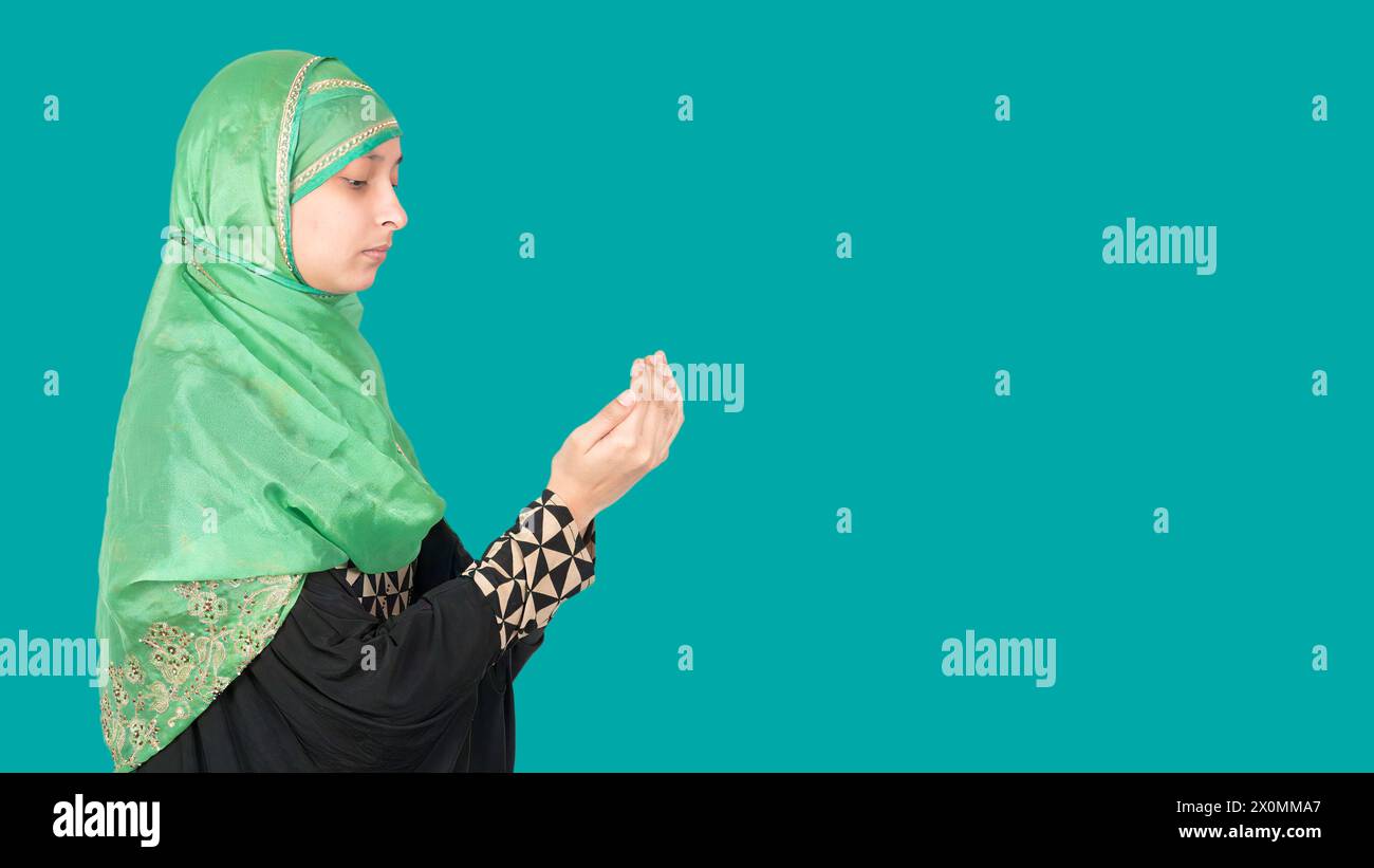 Seitenansicht eines muslimischen Mädchens mit erhabenen Aramen und Beten, Kopierraum Stockfoto
