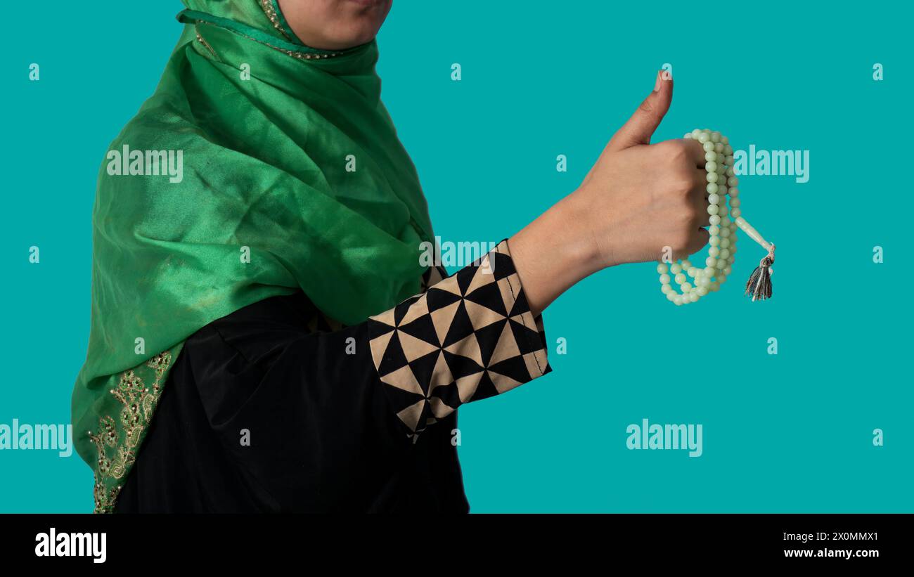 Muslimisches Mädchen betet zu Allah mit der Daumen-hoch-Geste mit Tasbeeh Stockfoto
