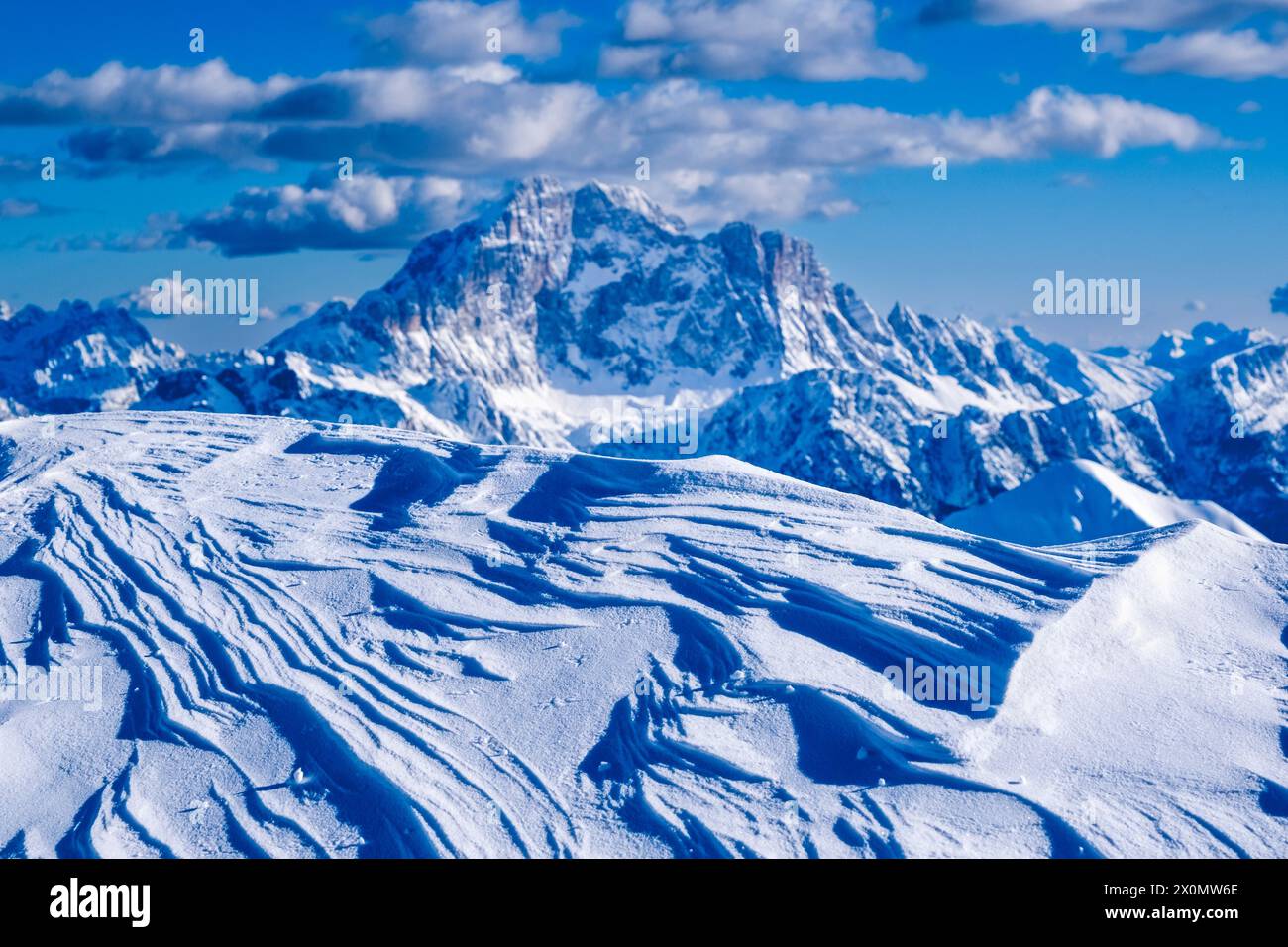 Schneetreiben unterhalb des Gipfels des Mt. Lagazuoi im Winter verschwimmerte der schneebedeckte Gipfel des Monte Civetta in der Ferne. Stockfoto