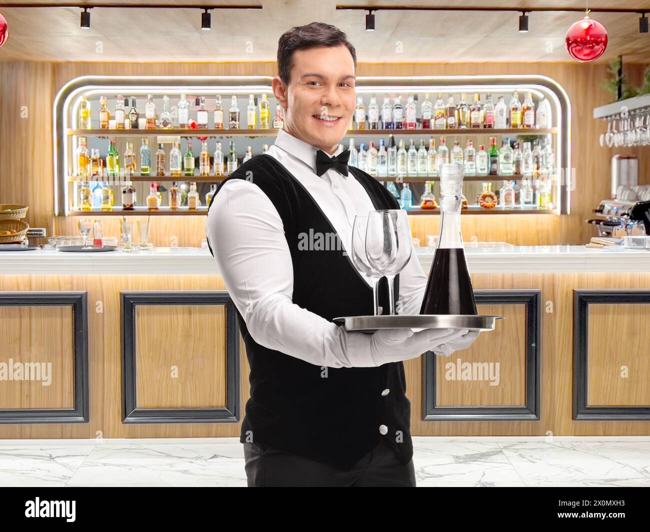 Kellner mit einem Tablett mit Rotwein und Gläsern in einer Bar Stockfoto
