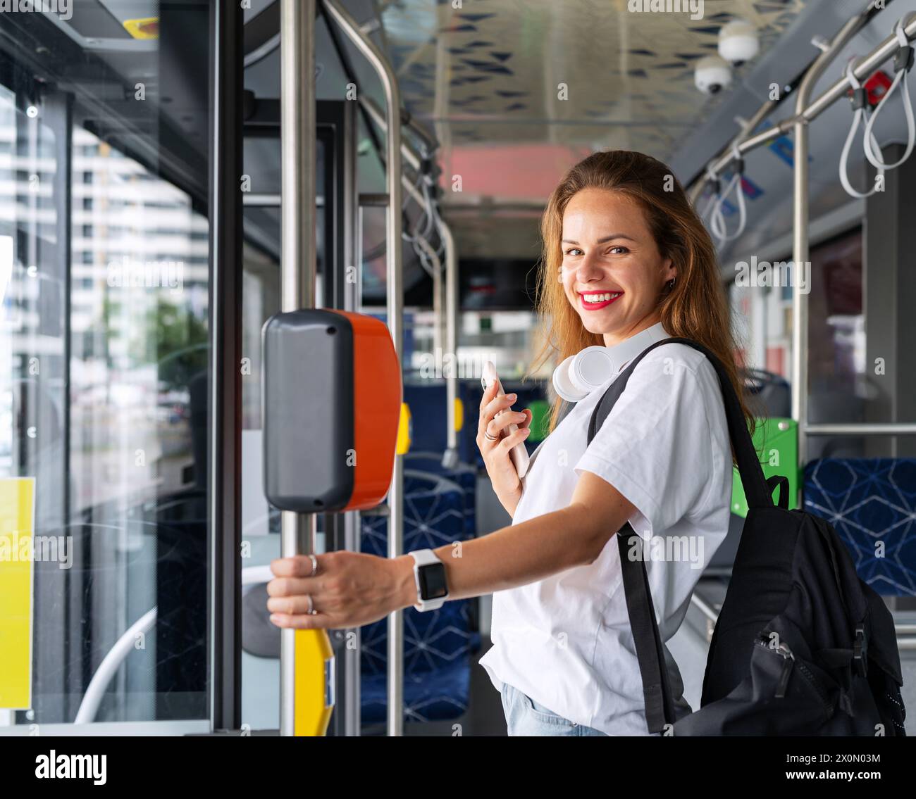 Hübsche brünette Frau, die mit öffentlichen Verkehrsmitteln unterwegs ist. Stockfoto