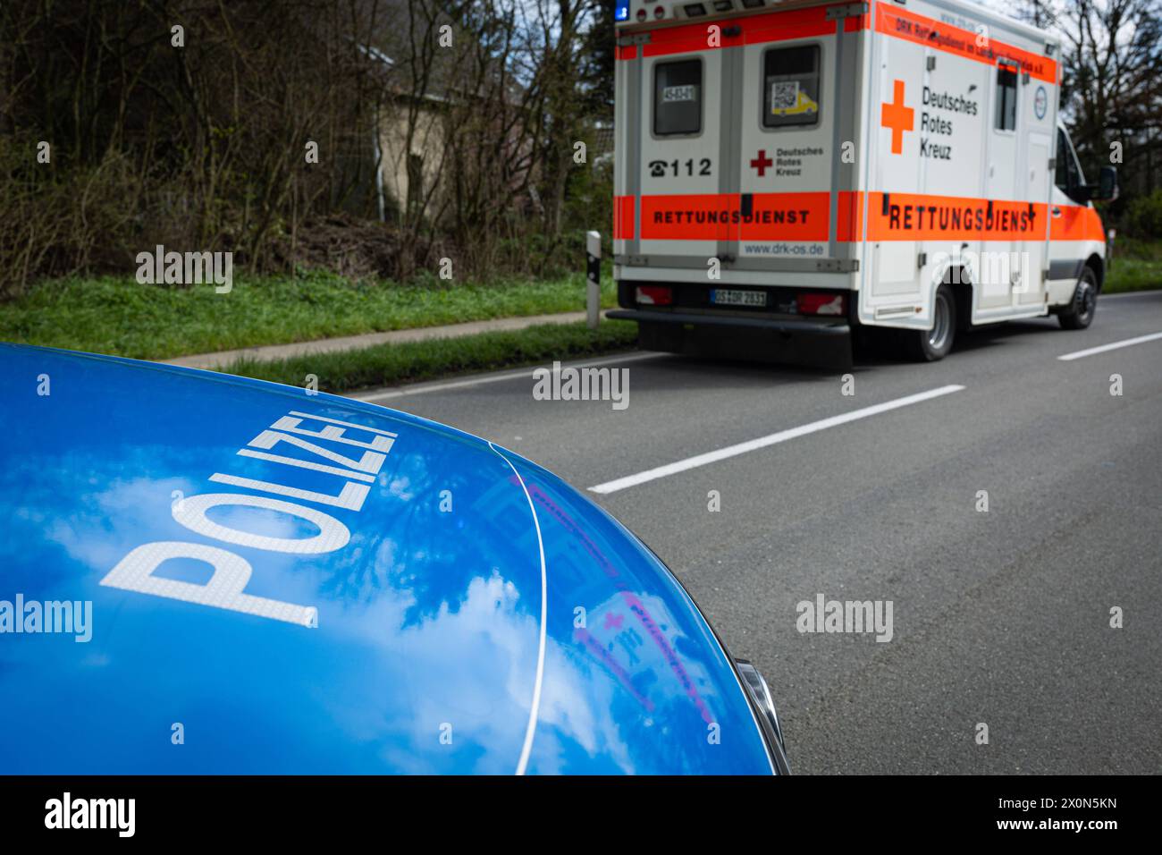 Melle, Deutschland 23. März 2024: Im Bild: Ein Einsatzfahrzeug, Streifenwagen, der Polizei steht mit Blaulicht und Schriftzug als Straßensperre auf einer Landstraße, im Vordergrund sieht man einen RTW, Rettungswagen an der Unfallstelle stehen. Landkreis Osnabrück Niedersachsen *** Melle, Deutschland 23. März 2024 auf dem Bild steht ein Rettungsfahrzeug, Patrouillenwagen, der Polizei mit blauen Lichtern und Schriftzeichen als Straßensperre auf einer Landstraße, im Vordergrund sieht man einen Krankenwagen, Krankenwagen am Unfallort Osnabrück Niedersachsen Copyright: xFotostandx/xGelhotx Stockfoto