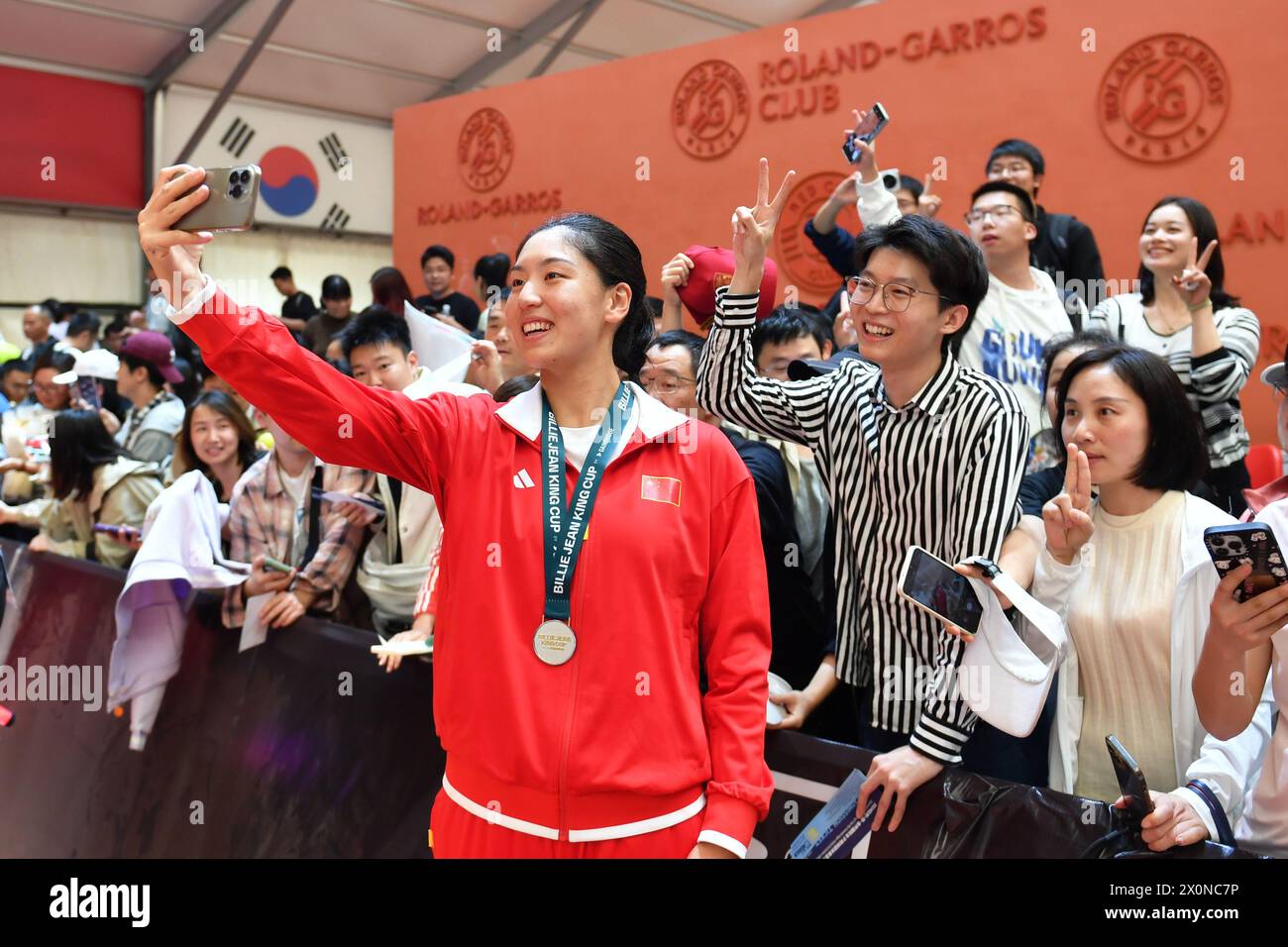 Changsha, Chinas Provinz Hunan. April 2024. Wang Xinyu (Front) aus China macht Selfies mit den Zuschauern nach dem Doppelspiel der Frauen zwischen Wang Xinyu und Guo Hanyu aus China und Kim Dabin/Park Sohyun aus Südkorea beim Billie Jean King Cup 2024 Tennis-Turnier Asien-Ozeanien Gruppe I Spiel in Changsha, zentralchinesische Provinz Hunan, 13. April 2024. Quelle: Chen Zhenhai/Xinhua/Alamy Live News Stockfoto