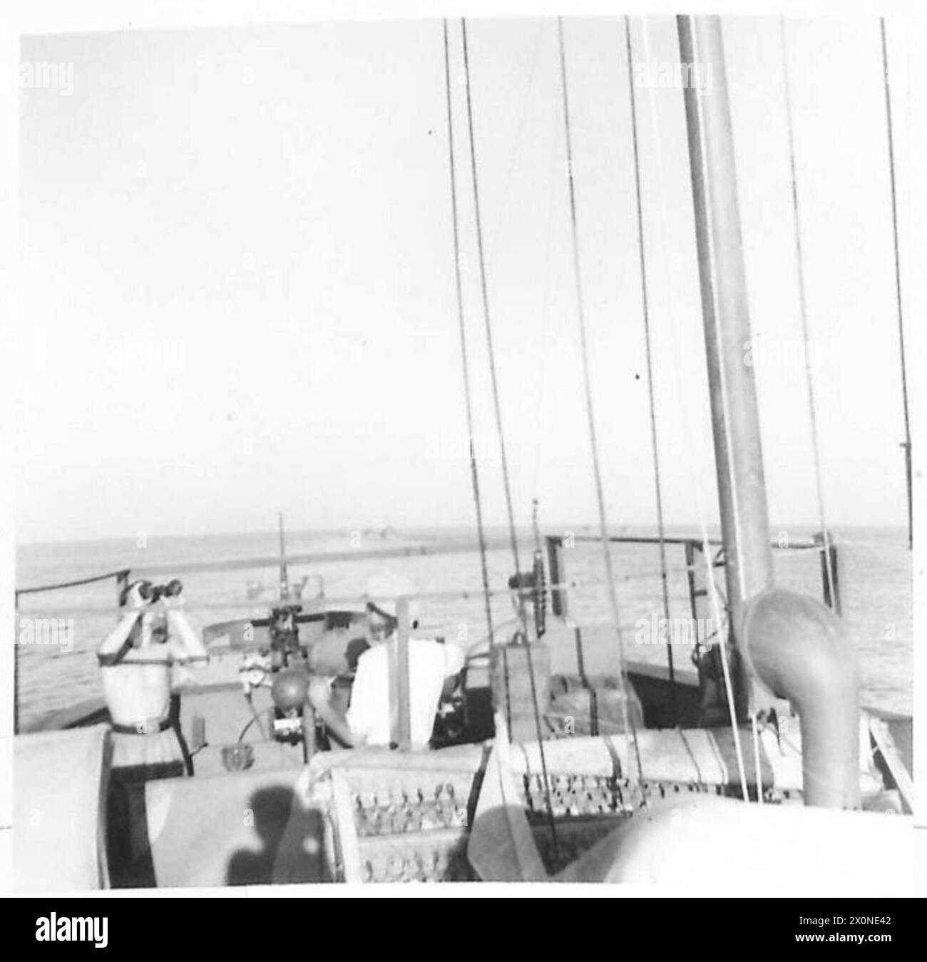 Ein Konvoi von vier LCIs, begleitet von MTBs, segelt in Richtung Albanien, wobei Lieutenant R.A. Johnson und ein Seemann auf der Brücke während eines Kommandoangriffs nach Flugzeugen suchen. Stockfoto