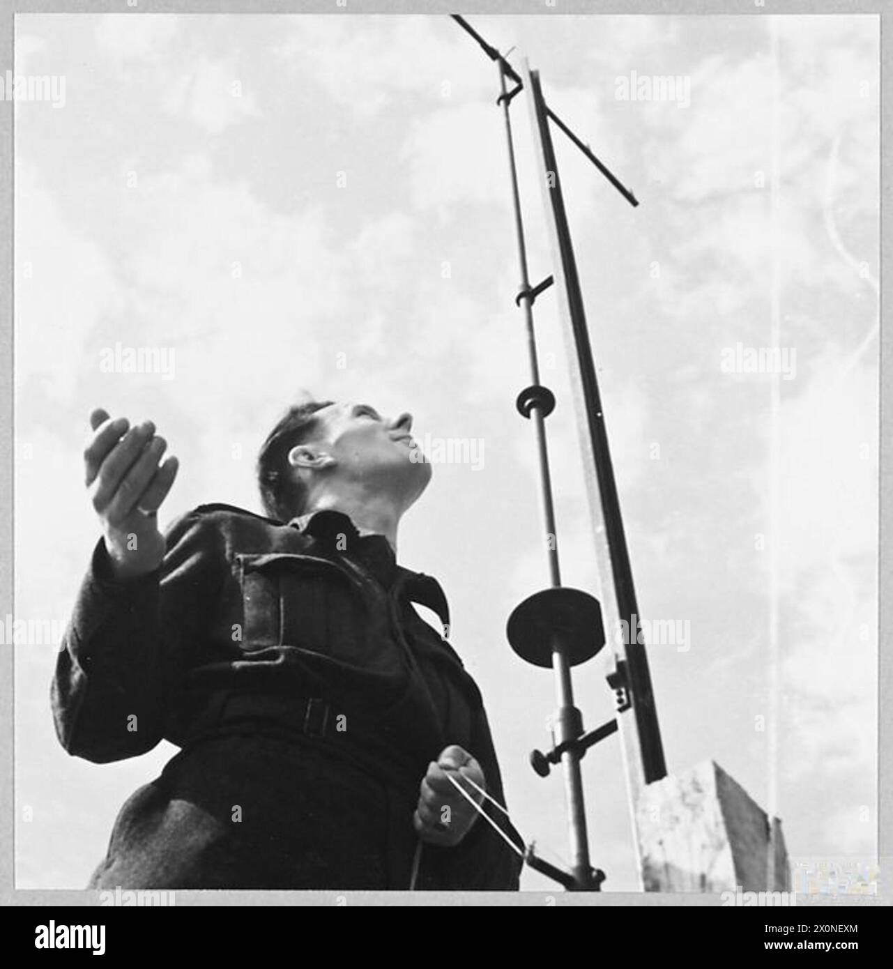 Flying Officer G.M.G. Lightbody verwendet eine Stoppuhr und ein Neophoskop, um mittlere und hohe Wolkenbewegungen zu beobachten und Windgeschwindigkeiten und -Richtungen im Jahr 1944 zu messen. Das fotografische negativ dokumentiert die meteorologische Arbeit der RAF. Stockfoto