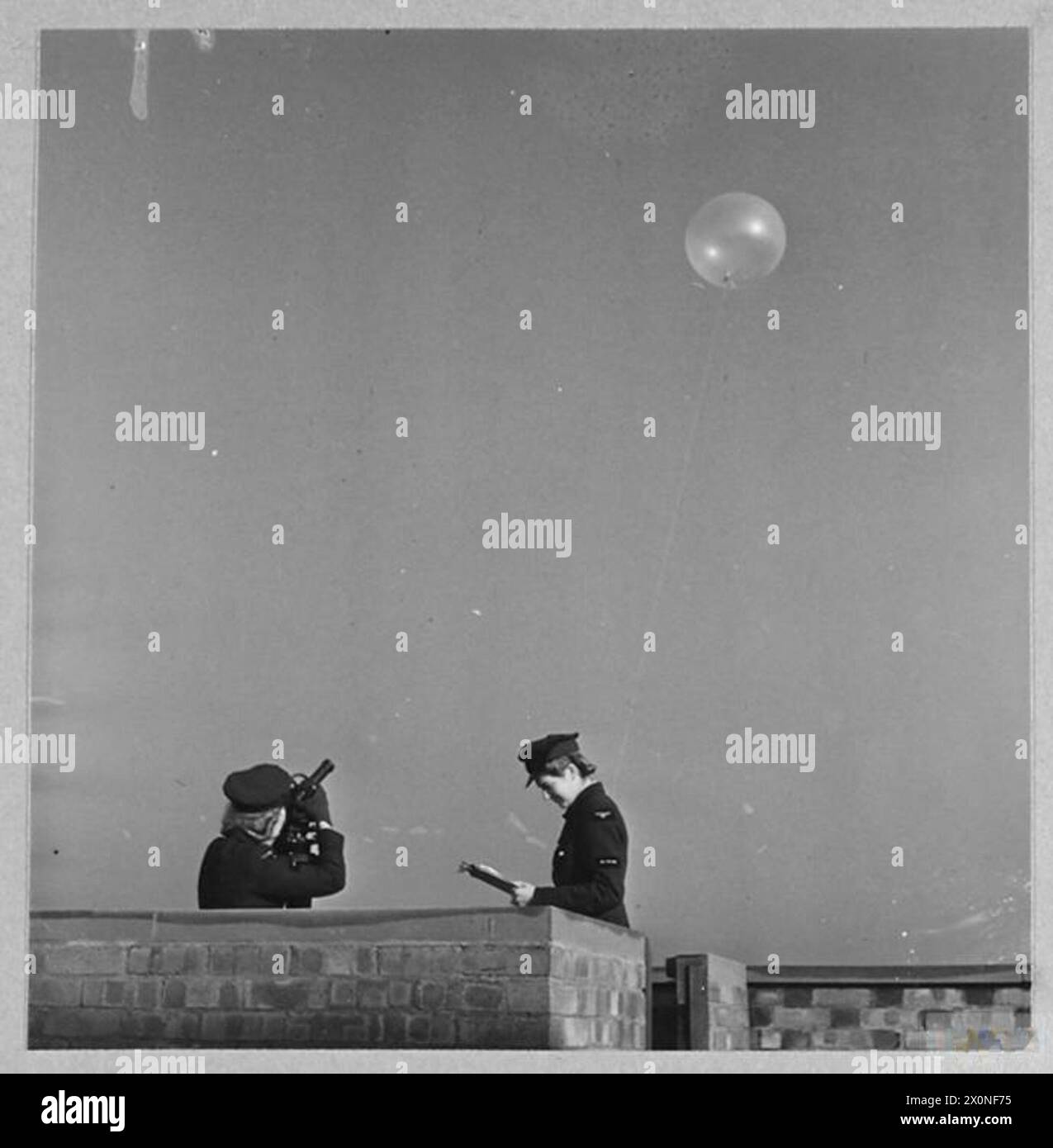 WAAF-Mitarbeiter lassen einen Wetterballon frei und verfolgen seinen Kurs mit einem Theodoliten, um die Windgeschwindigkeit für RAF-Operationen zu schätzen. Stockfoto