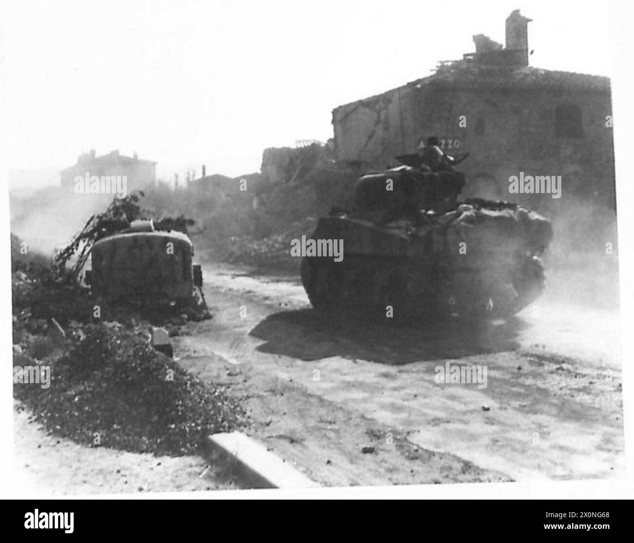 Die Panzerpanzer der 16/15 Lancers dringen in Arezzo ein, während die verbliebenen Zivilisten die Rüstung beobachten und jubeln. Stockfoto