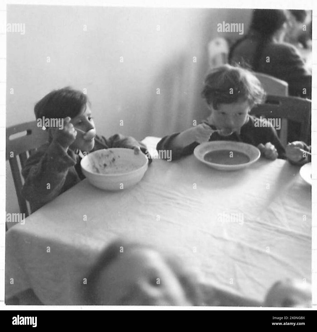 Polnische, niederländische, französische und ungarische Kinder essen in Speisesälen des Konzentrationslagers Bergen-Belsen, Lager Nr. 2, das im April 1945 zu einem Krankenhaus und Evakuierungszentrum umgebaut wurde. Fotografisches negativ. Stockfoto