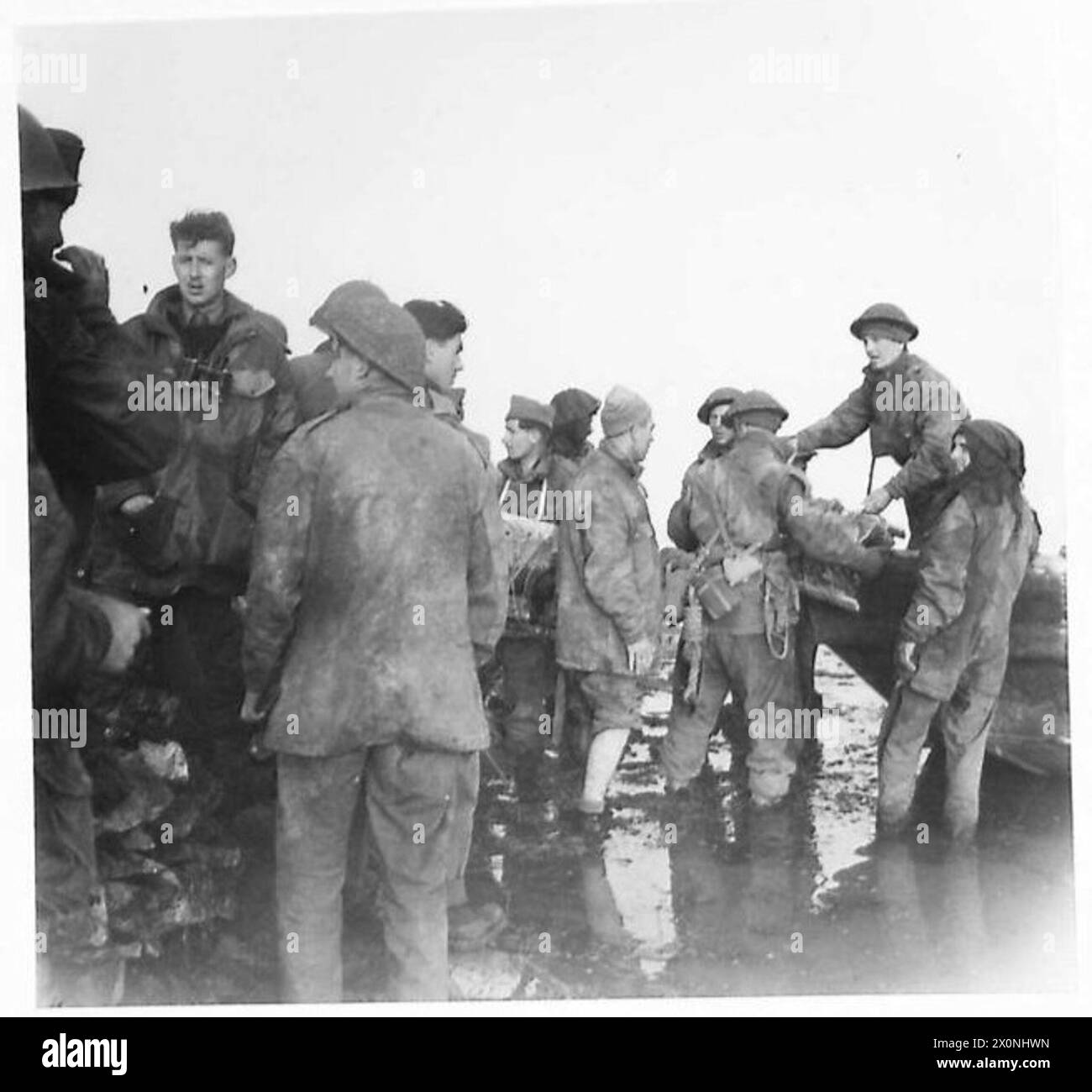 Royal Marine Commandos of X40 Heavy Weapons entladen ihr Boot während Operationen mit schwerem Mörserfeuer, das in einem Fotonegativ der britischen Armee erfasst wurde. Stockfoto