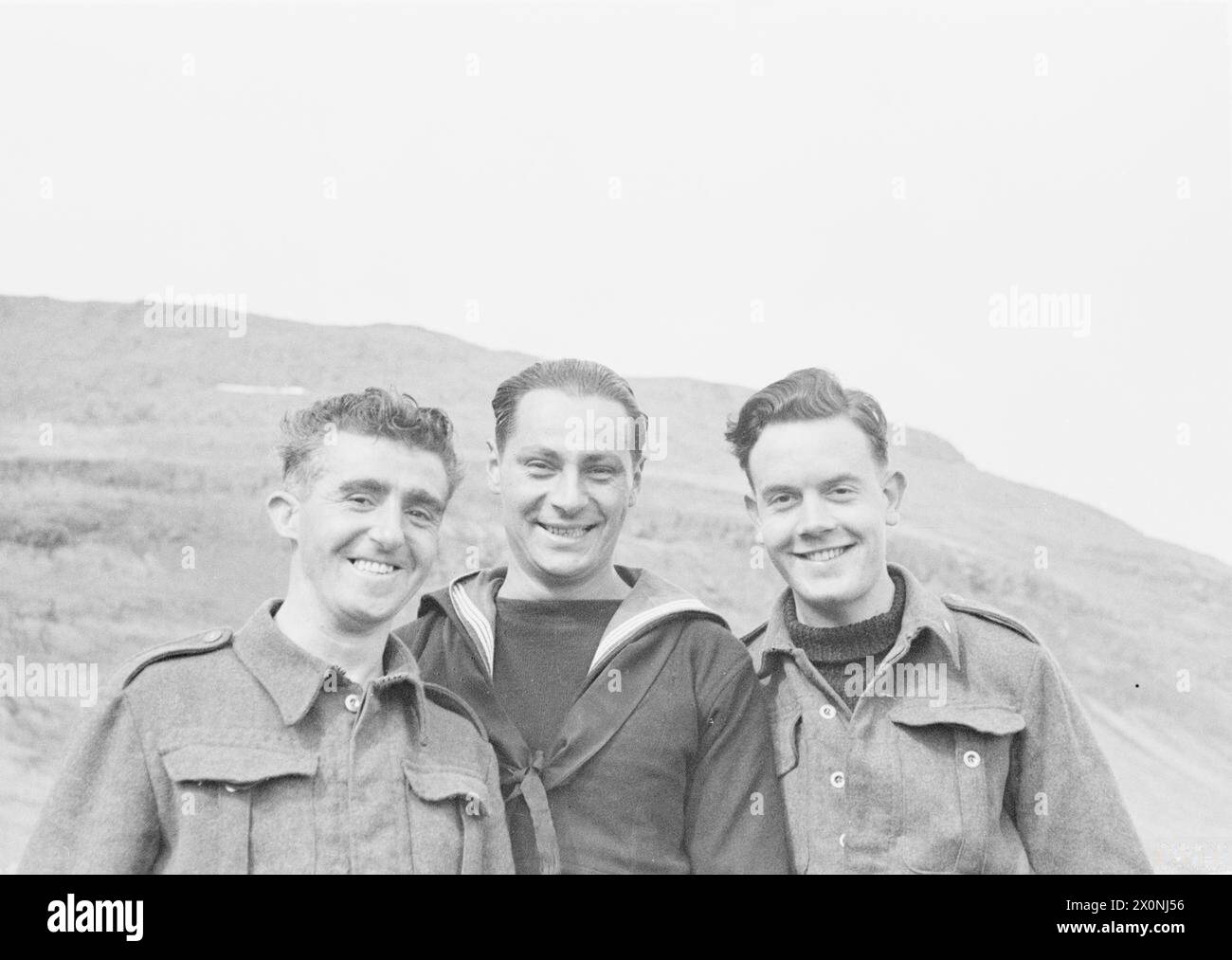 Vier Seeleute sind an einem isolierten Aussichtsposten im Nordwesten Islands stationiert, 40 Meilen von der nächsten Siedlung entfernt, während die HMS Suffolk im Mai 1941 das Gebiet patrouilliert. Stockfoto
