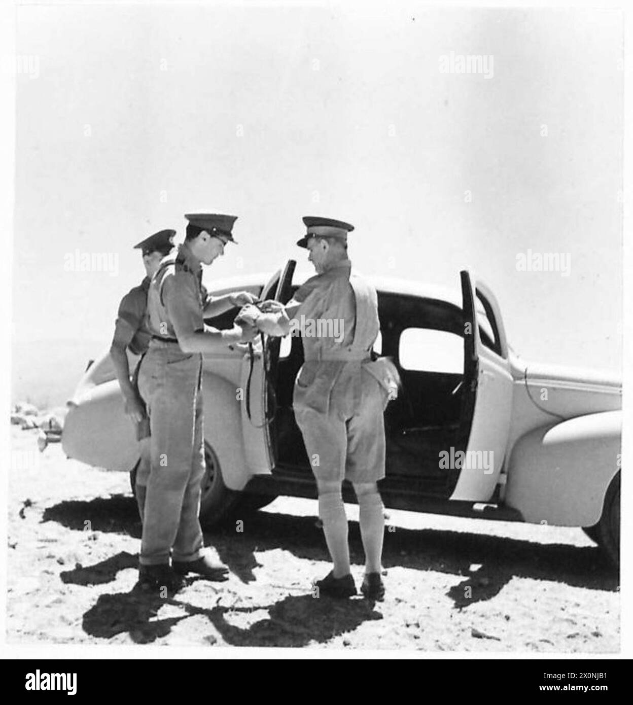 GENERAL WAVELL BESUCHT DIE FRONT IN SYRIEN UND BEOBACHTET OPERATIONEN WÄHREND SEINES AUFENTHALTS - General Wavell übergibt seine Feldbrille seinem A.D.C.-Fotonegativ, British Army Stockfoto