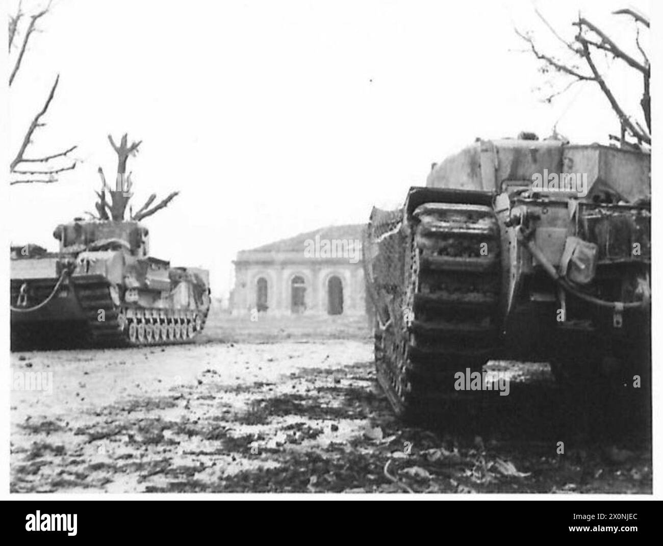 Zwei Panzer der britischen Armee beschossen feindliche Positionen nördlich des beschädigten Bahnhofs Faenza, während sie unter deutschem Mörserfeuer standen, was die Panzerkämpfe in Nordafrika, Sizilien, Italien, dem Balkan und Österreich veranschaulicht. 1942-1946. Stockfoto