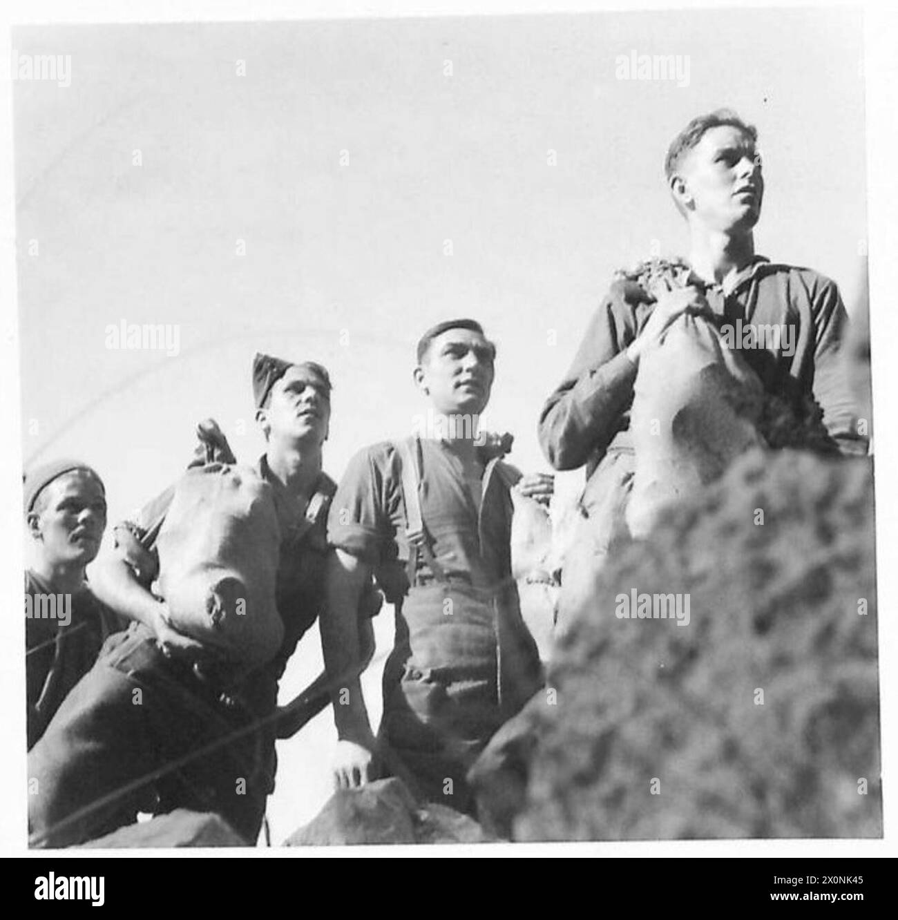 Fusiliers von der britischen Fünften Armee, die an der italienischen Front Vorräte aufnahm, identifiziert als Gr. Trim, G. Johnson, L. Rowntree und H. Smith aus verschiedenen britischen Standorten. Ein fotografisches negativ dokumentiert die Operation. Stockfoto