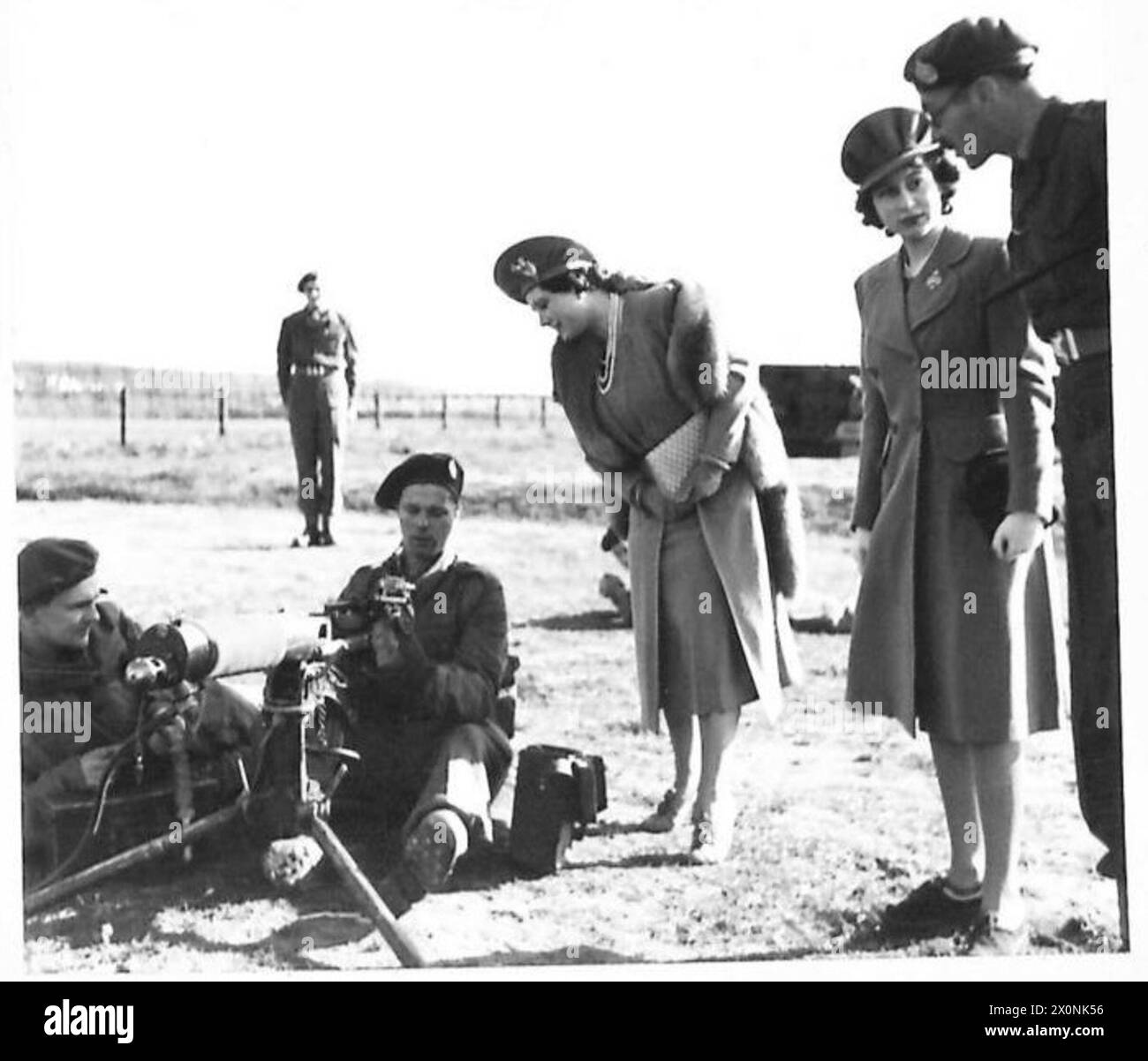 Ein Offizier spricht mit Prinzessin Elizabeth, während König George mit einem Maschinenschützen spricht. Fotografisches negativ, britische Armee. Stockfoto