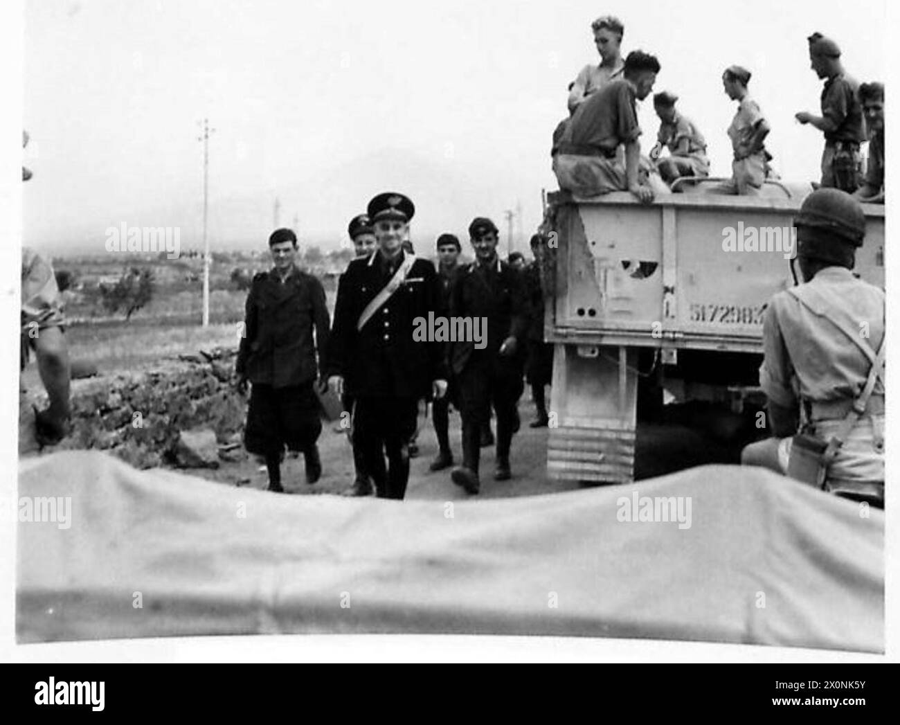 Die italienische Polizei beaufsichtigt Gefangene, die aus Catania kommen, um sich mit anrückenden Truppen der 8. Armee zu treffen. Fotografisches negativ, britische Armee. Stockfoto