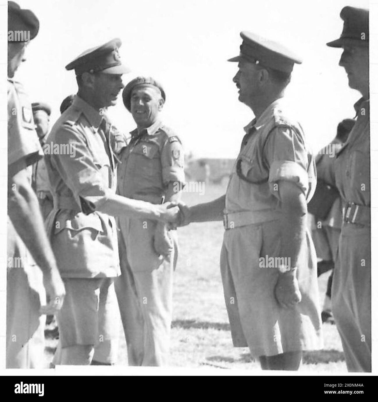 DIE POLNISCHE ARMEE IM ITALIENISCHEN FELDZUG, 1943-1945: König Georg VI. Schüttelte während seines Besuchs bei der britischen 8. Armee die Hand mit Brigadegeneral Eric Frith, dem britischen Verbindungsoffizier des 2. Polnischen Korps. Oberstleutnant R. F. G. Jayne (ganz rechts), der CO der 7. Queen's Own Husars, wartet darauf, dass er an der Reihe ist, um den König zu treffen. General Władysław anders, der Befehlshaber des 2. Korps, stellt beide Offiziere vor: Flugplatz Castiglione del Lago, 26. Juli 1944 britische Armee, polnische Armee, polnische Streitkräfte im Westen, polnische Armee, polnische Armee, polnische Armee, polnische Korps, II., 7. Queen's Own Hussars, Georg VI., König, anders, Władysł Stockfoto