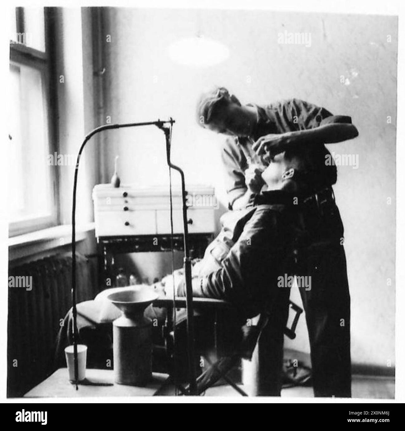 Auf der Oflag 79 in Deutschland wird ein Lagerzahnarzt gezeigt, der in seiner Chirurgie arbeitet und das Leben von Kriegsgefangenen reflektiert. Fotografisches negativ der britischen Armee, 21. Armeegruppe. Stockfoto
