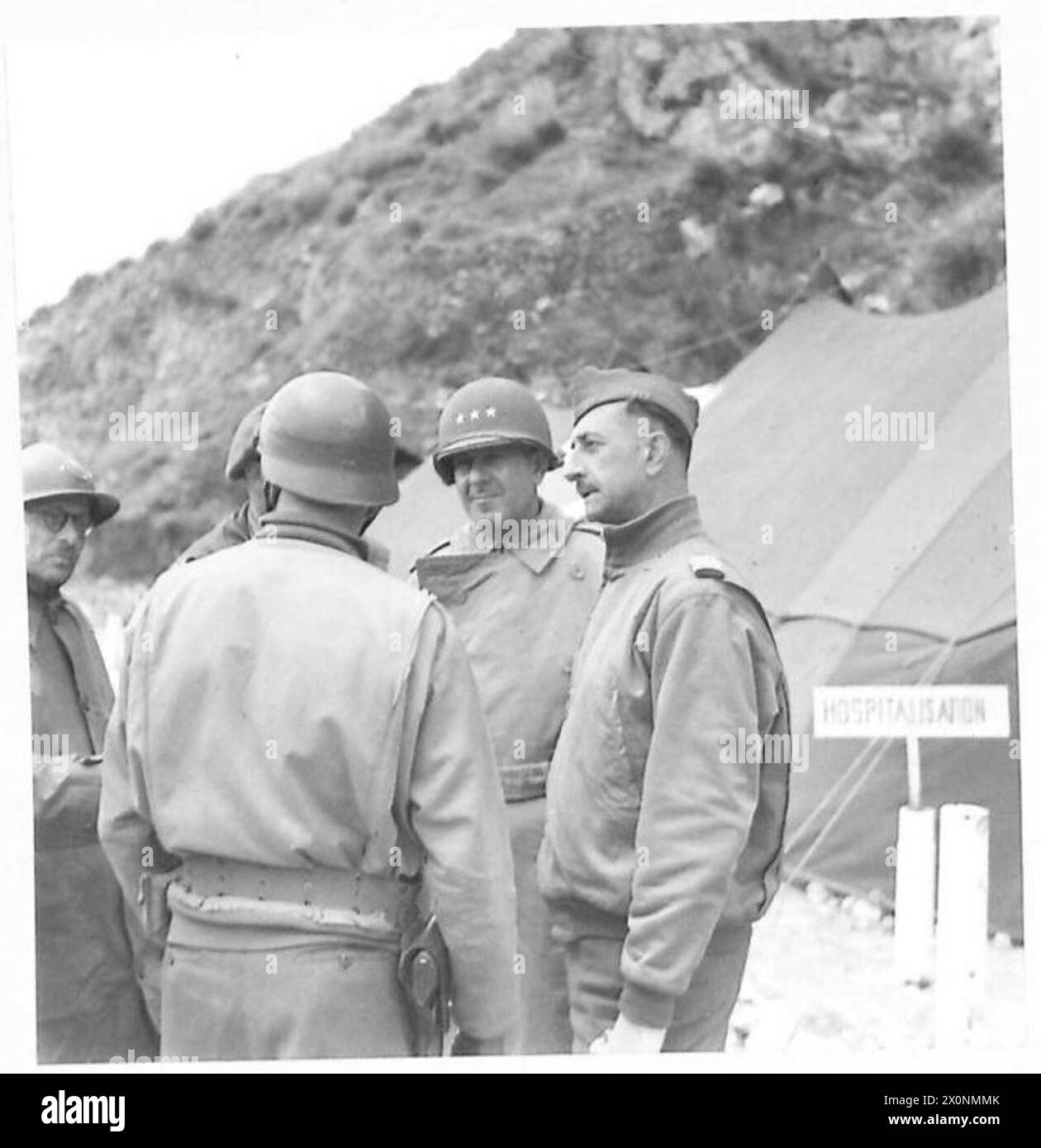 ITALIEN: GENERAL DEVERS BESUCHT TRUPPEN - General Devers spricht mit zwei französischen Ärzten nach einer Inspektion eines französischen Krankenhauses. Fotografisches negativ, britische Armee Stockfoto