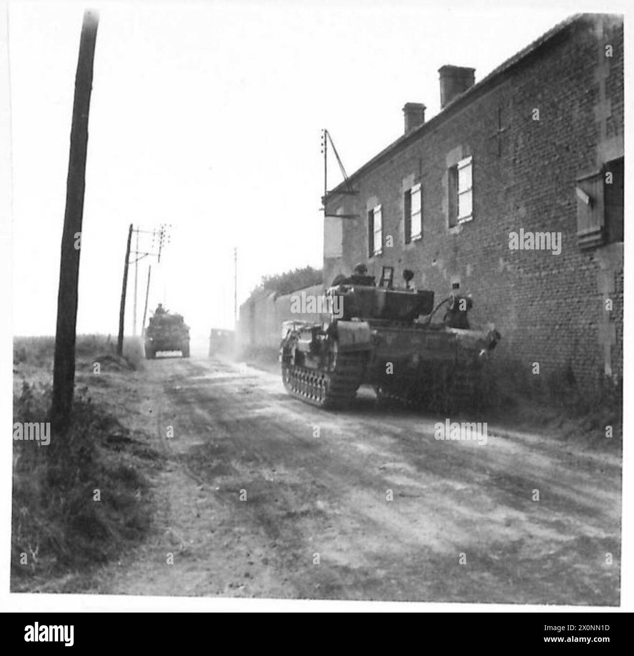 Ein Churchill AVRE-Panzer des 5. Sturmregiments, Royal Engineers, 79th Armoured Division, ist in der Nähe von Hermanville mit einem Sherman-Panzer im Hintergrund am 7. Juni 1944 abgebildet, der die Operationen der britischen Armee während des Normandie zeigt. Stockfoto