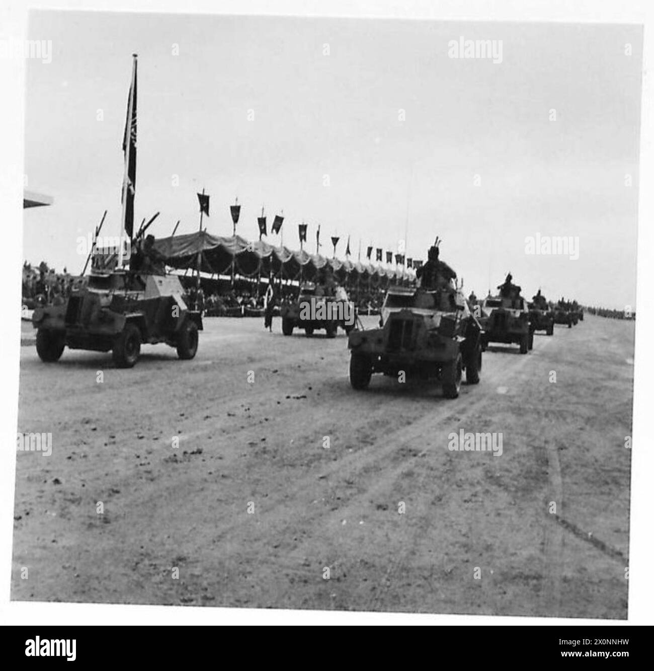 König Ibn Saud beobachtet im Rahmen der militärischen Demonstration eine Parade von kürzlich erworbenen ägyptischen gepanzerten Fahrzeugen. Stockfoto