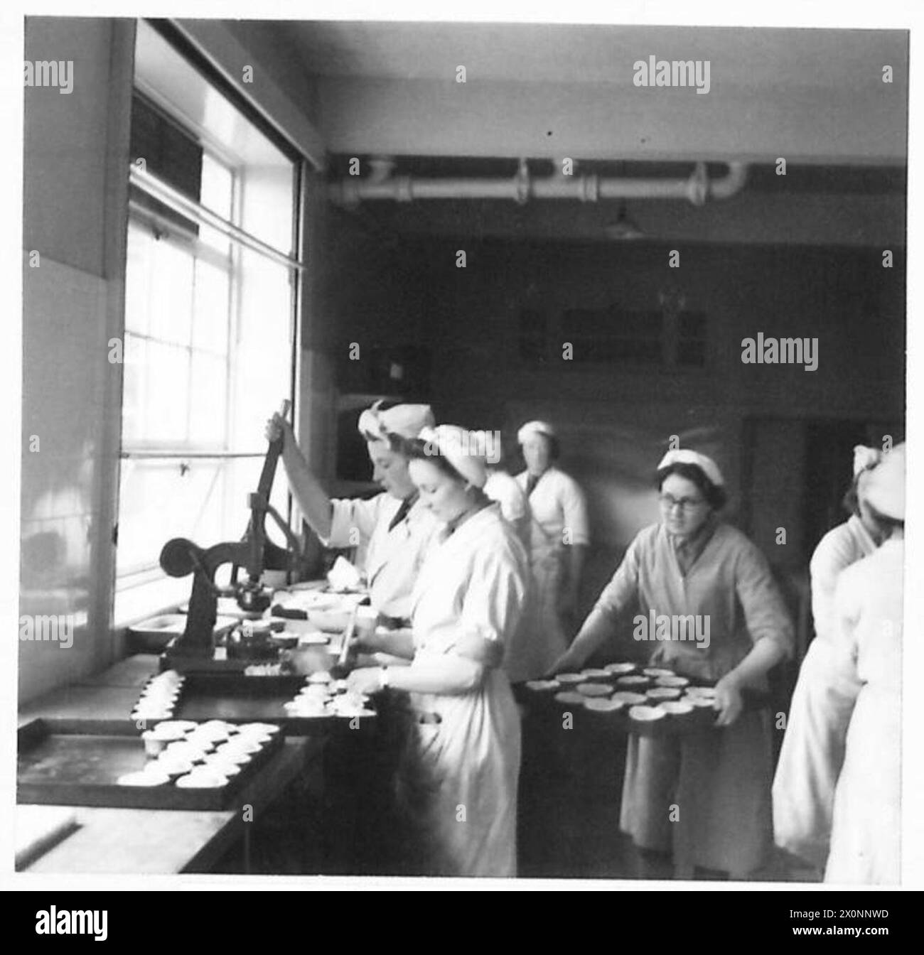 Mitglieder des Auxiliary Territorial Service werden in einer Kochschule unterrichtet, Kuchen zu machen. Fotografische Negativdokumente der britischen Armee Ausbildung in kulinarischen Fähigkeiten. Stockfoto