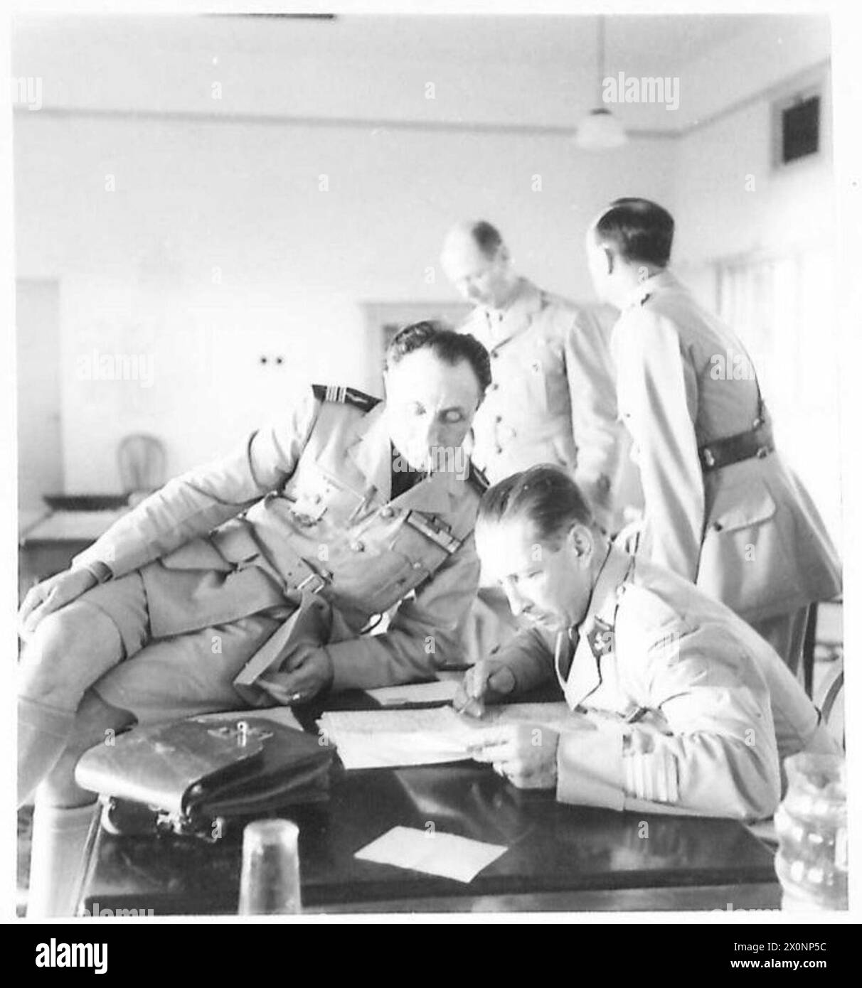 Zwei freie französische Offiziere, die an der Britischen Friedenskonvention anwesend sind, werden gezeigt, wie sie eine Karte von Syrien studieren, die in einem fotografischen negativ der Britischen Armee erfasst wurde. Stockfoto