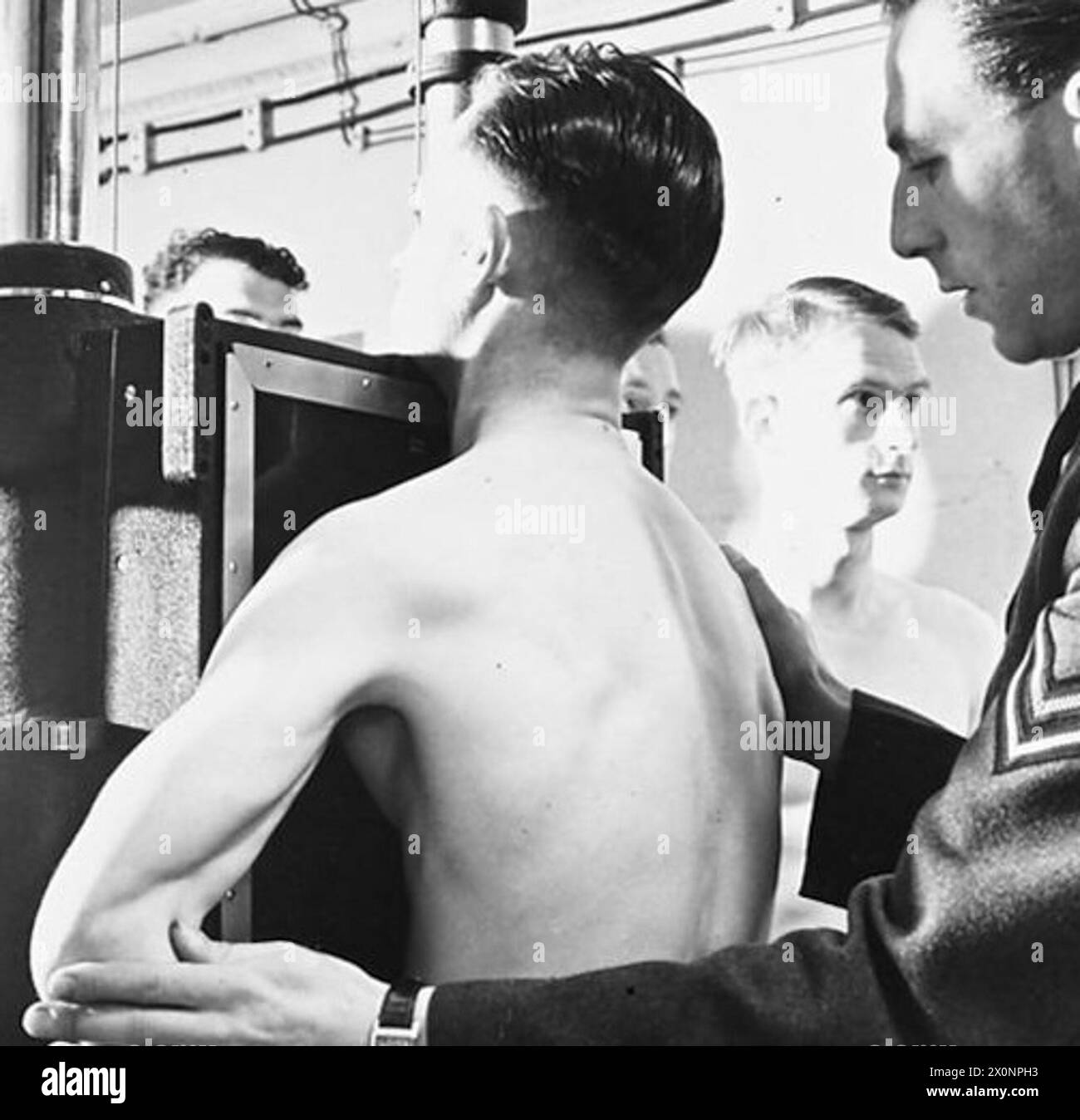 MASSENRADIOGRAPHIE EINER FLUGBESATZUNG - für die Geschichte siehe CH.9938 Bild (ausgestellt 1943) zeigt - Mitglieder einer Flugbesatzung werden geröntgt. Fotografisches negativ, Royal Air Force Stockfoto