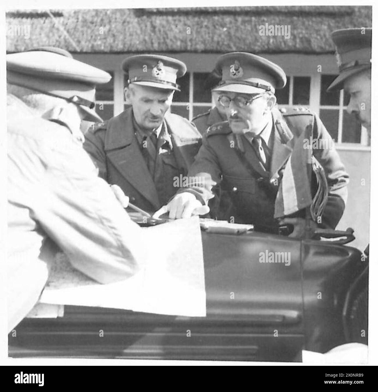 Der Oberbefehlshaber der britischen Armee untersucht Karten auf der Motorhaube seines Wagens während der Stoßfänger-Übung, um Operationen zu steuern. Stockfoto