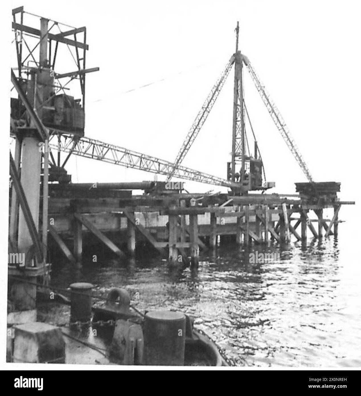 Fotografisches negativ mit Fortschrittsarbeiten an Larne Jetty mit einem Dampfentrick, das Ingenieurwesen und Bauarbeiten der British Army dokumentiert. Stockfoto
