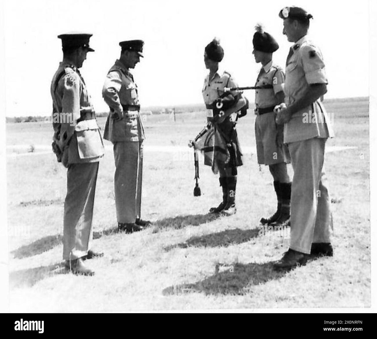 Das Foto zeigt Feldmarschall Alexander, der Pola besucht und Pipe Major J.R. Franklin und Bugle Major F.J. Taylor von der 1st London Irish Rifles Pipe Band auf dem Flugplatz vorgestellt wird, begleitet von Lieut. General Sir John Harding und Brigadier Scott-Elliott. Das Bild ist ein fotografisches negativ, das mit der britischen Armee in Verbindung gebracht wird. Stockfoto