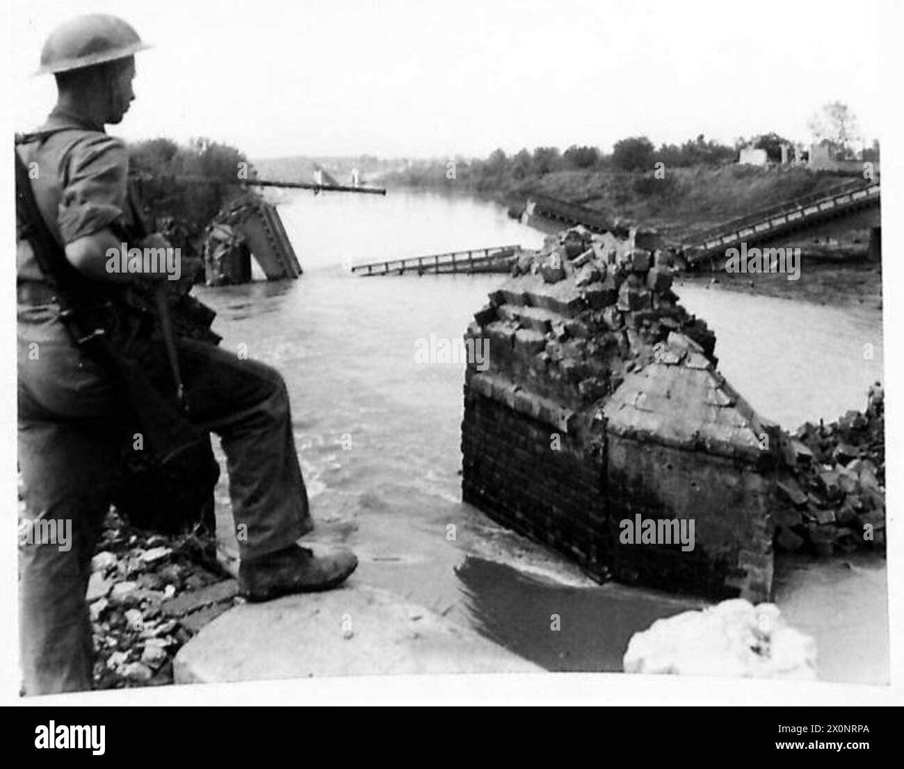 ITALIEN FÜNFTE ARMEE-FRONT SCHWIMMENDE PONTON BAILEY-BRÜCKE - ein Beispiel für deutsche Gründlichkeit beim Abriss und der Grund, warum diese Brücke gebaut werden musste. Der Feind sprengte an dieser Stelle drei Brücken, im Vordergrund die alte Steinbrücke, dann eine modernere Brücke, und weiter oben sind die Überreste der Eisenbahnbrücke zu sehen. Fotografisches negativ, britische Armee Stockfoto