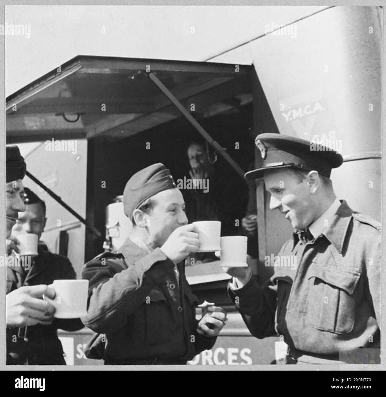 DIE POLNISCHE LUFTWAFFE IN GROSSBRITANNIEN, 1940-1947 – Bodenstab der polnischen Jagdgeschwader Nr. 303 toasten sich in Tee vor der mobilen YMCA-Kantine bei der RAF Northolt polnische Luftwaffe, polnische Luftwaffe, 303 'Kościuszko' Jagdgeschwader, Junge Männer christliche Vereinigung Stockfoto