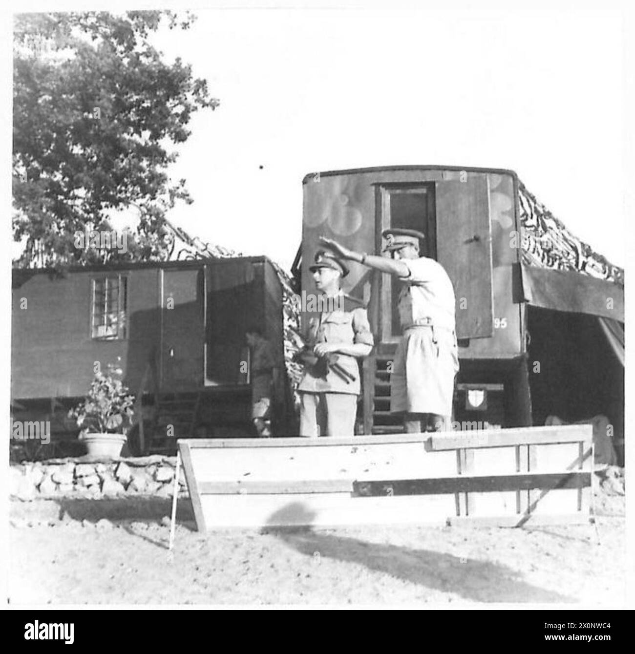 H.M. der König und General Leese überprüfen feindliches Territorium anhand einer Panoramakarte vor einer Karawane im TAC HQ, Achte Armee, wo der König die Nacht verbrachte. Fotografisches negativ, britische Armee. Stockfoto