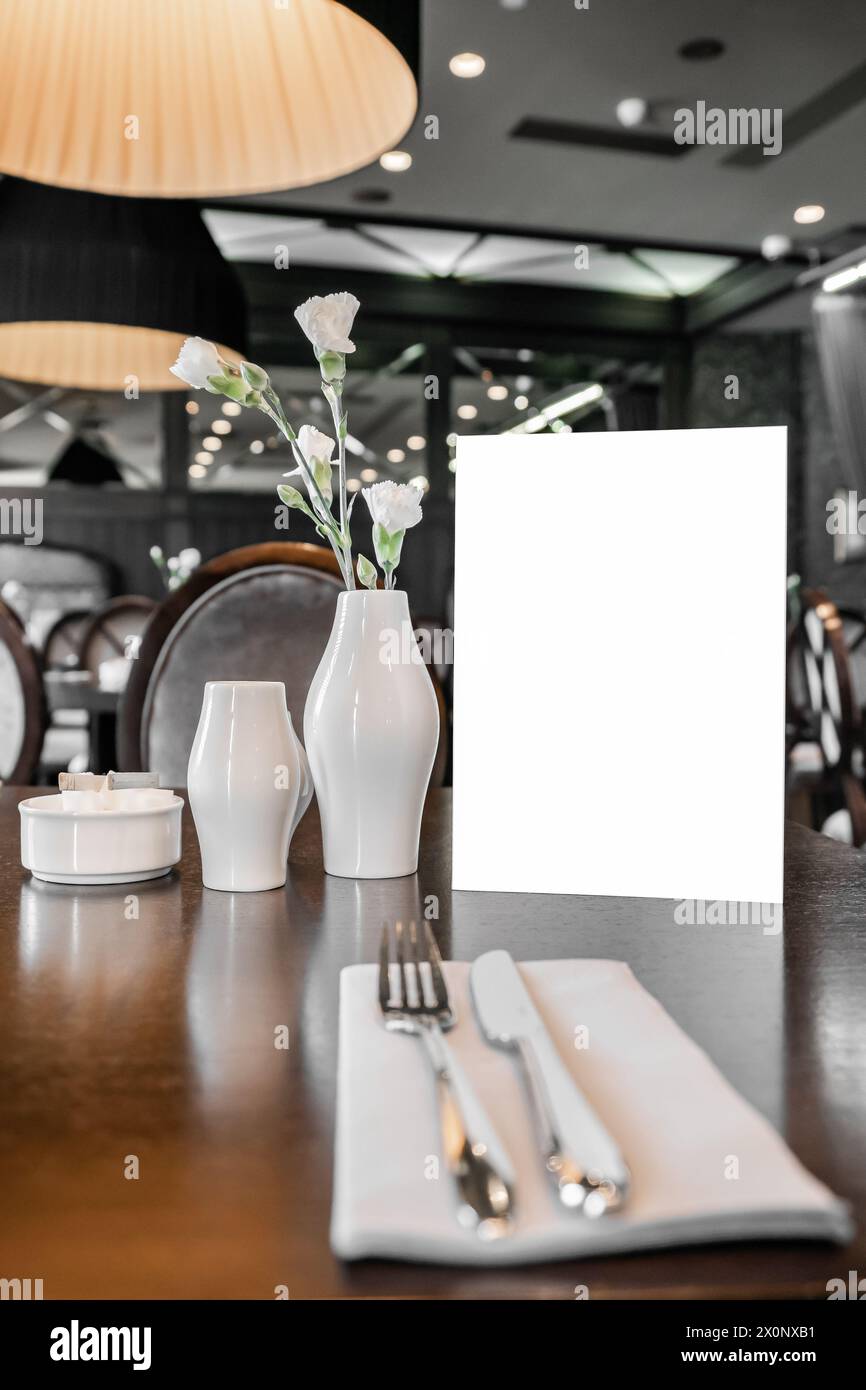 Servierter Tisch im Restaurant mit leerem Mockup-Menü für Werbetext und Design Stockfoto