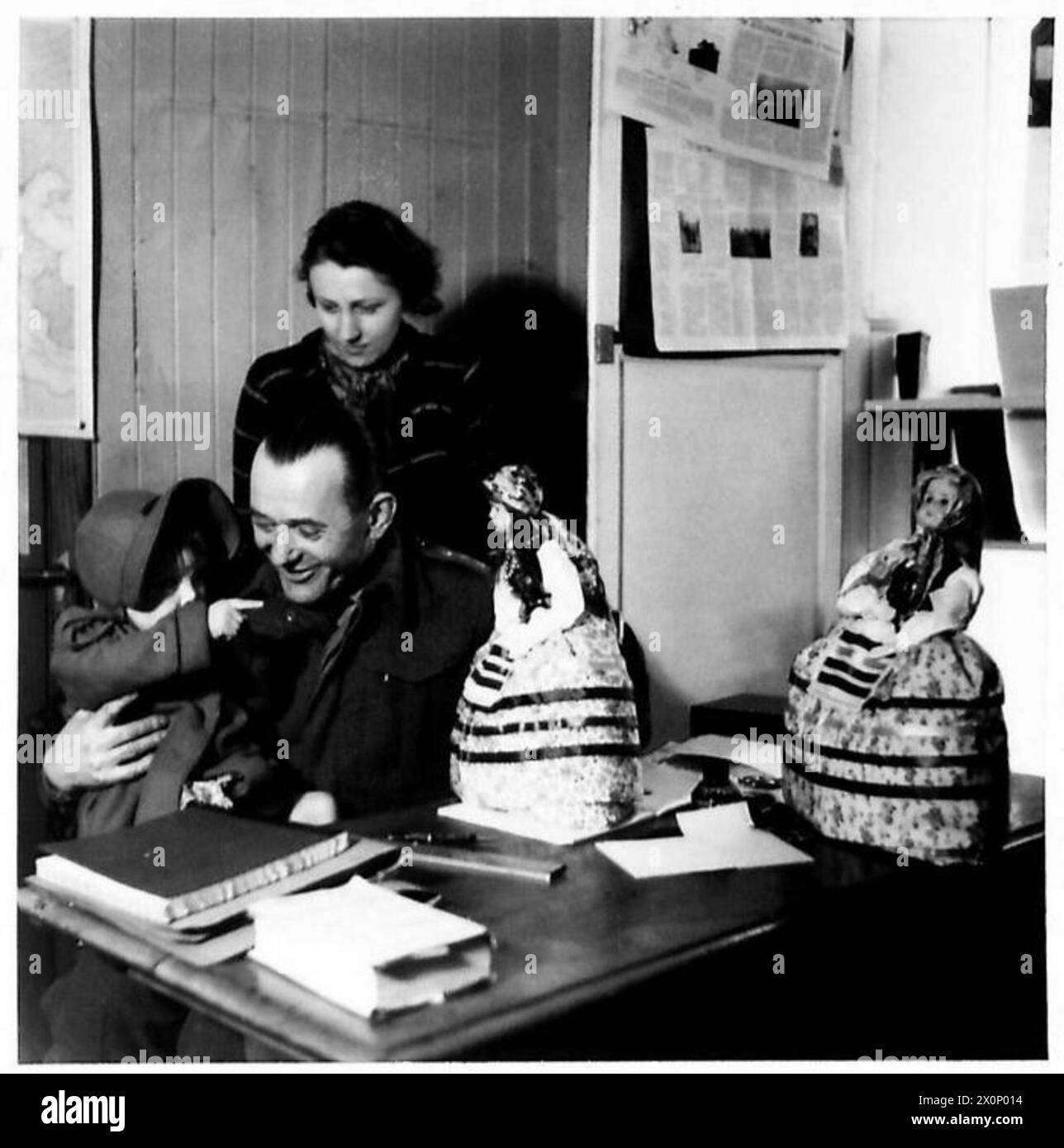 Ein Kapitän der polnischen Armee zeigt in einem Geschäft in Cupar eine schottische Kinderpuppe in traditionellen Volkstrachten, die das soziale Leben der 1. Schützenbrigade (1. Polnisches Korps) in Schottland während des Zweiten Weltkriegs reflektiert. Stockfoto