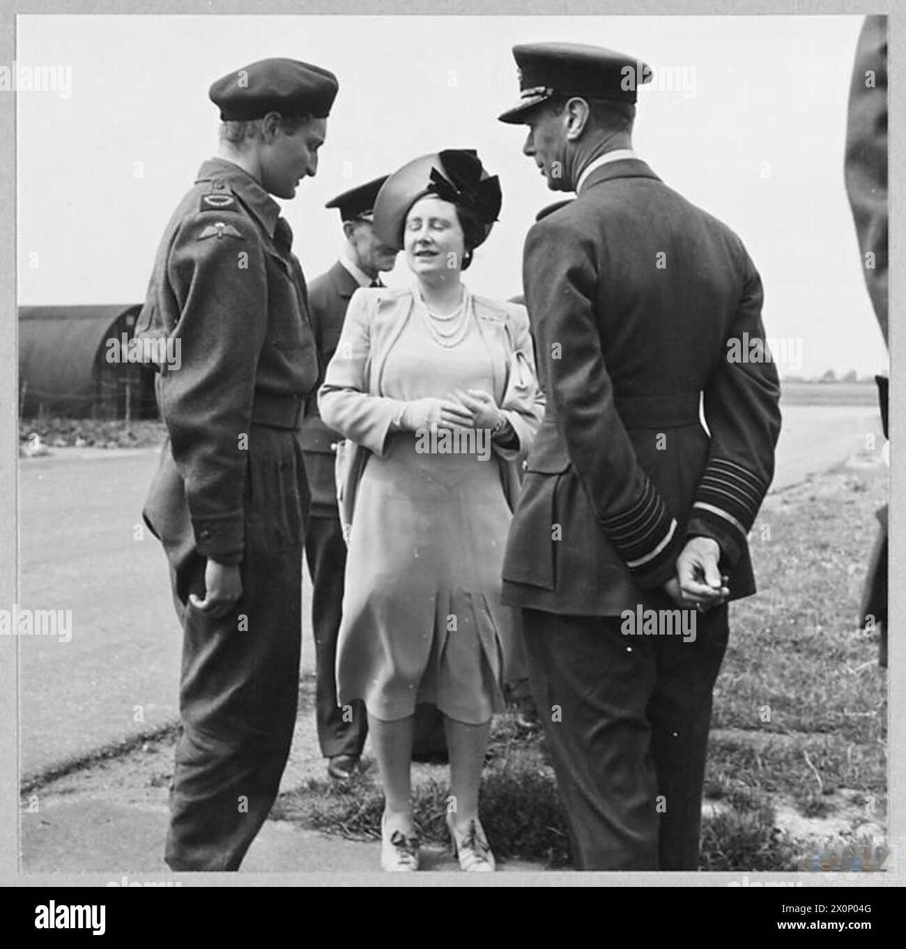 Der König und die Königin treffen Guy Byam, BBC-Kriegskorrespondent und Teilnehmer der Luftlandedivision am D-Day, während eines königlichen Besuchs im Jahr 1944. Stockfoto