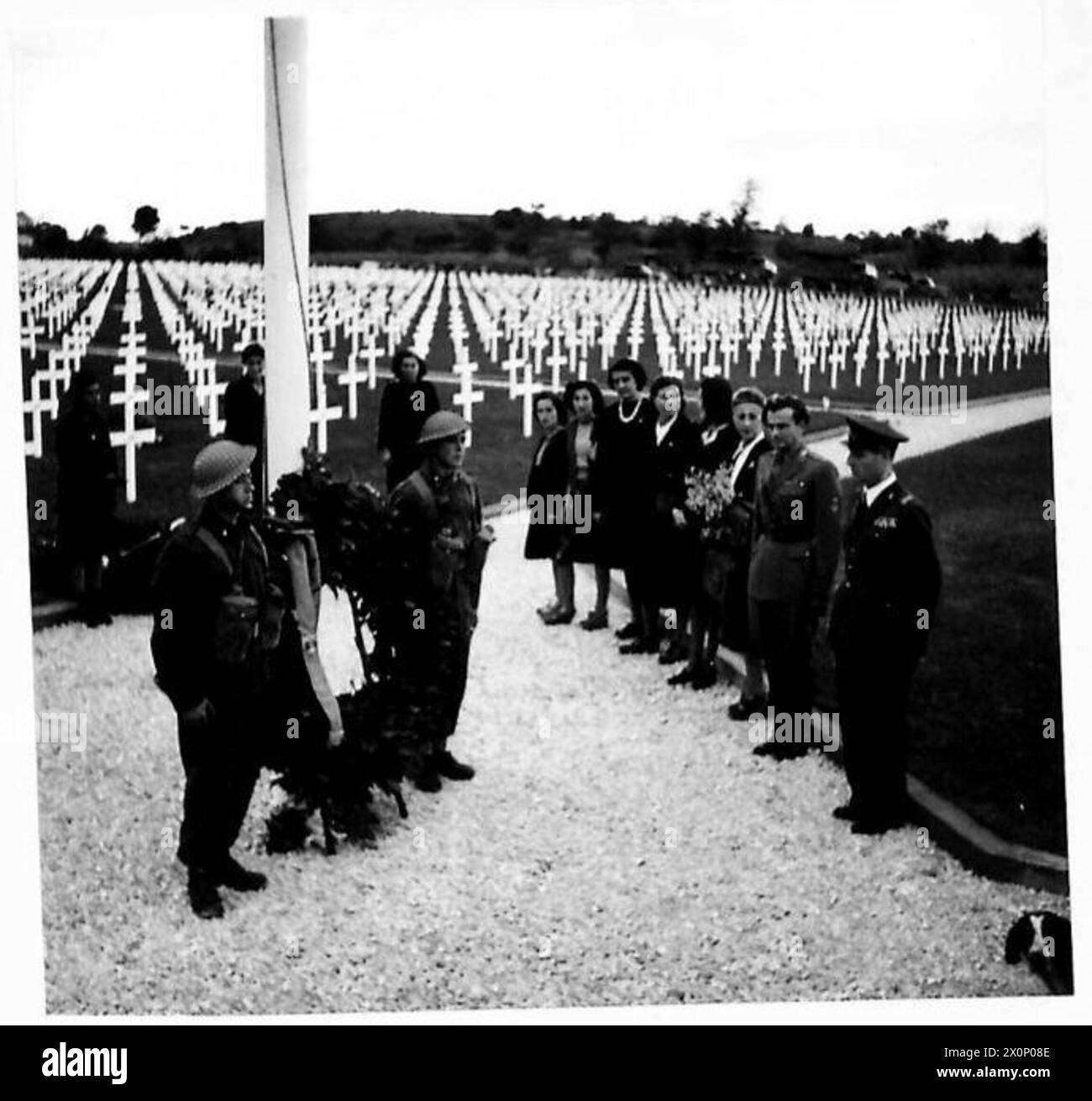 Italienische Soldaten bilden eine Ehrengarde, nachdem sie Kränze unter eine Flagge gelegt haben, um gefallene alliierte Soldaten zu ehren. Fotografisches negativ der britischen Armee. Stockfoto