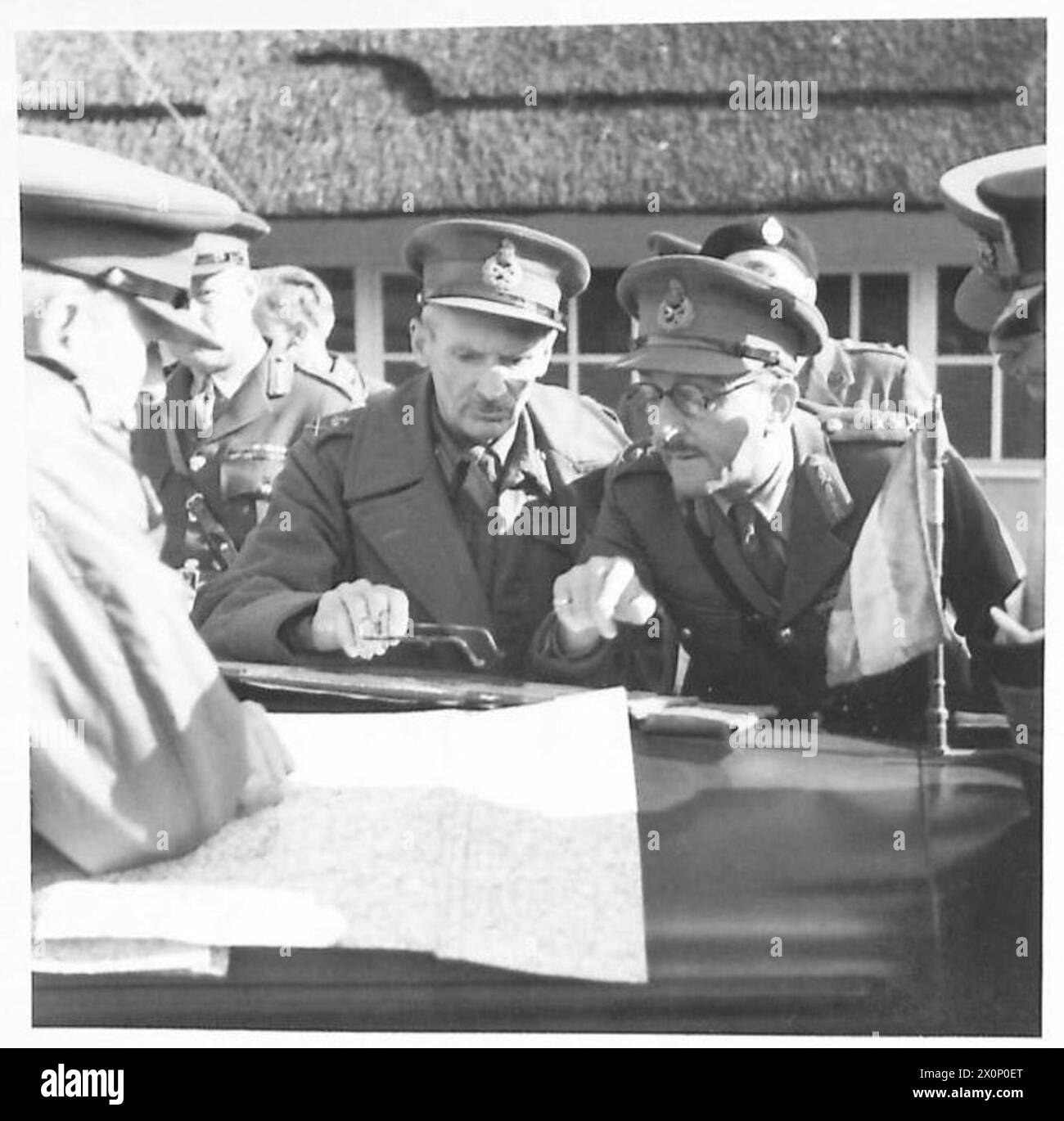 Foto, das den britischen Oberbefehlshaber zeigt, der die Militäroperationen leitet und während einer großen Übung Karten auf der Motorhaube seines Wagens studiert. Stockfoto
