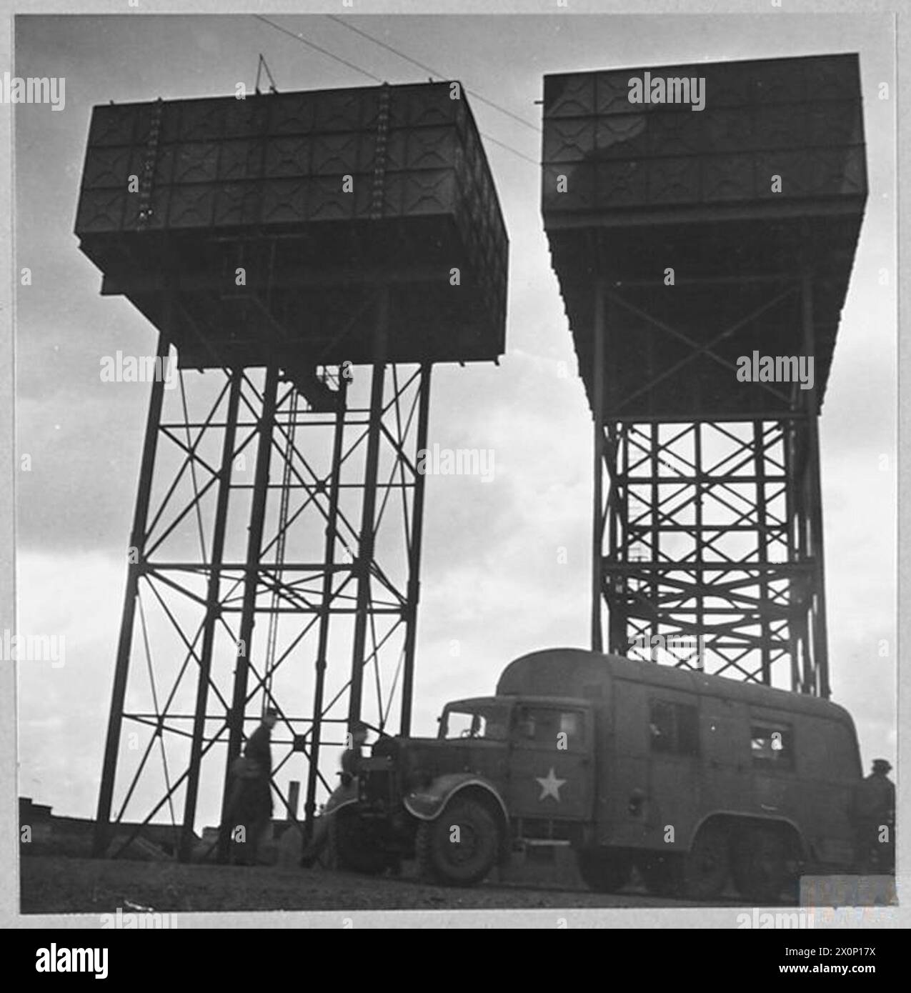 Das Foto zeigt zwei große Wassertanks auf einer Farm, die Wasser für eine neue Siedlung im amerikanischen Stil liefern. Das fotografische negativ von 1944 dokumentiert die Infrastruktur und die Wasserspeicherung auf dem Bauernhof. Stockfoto