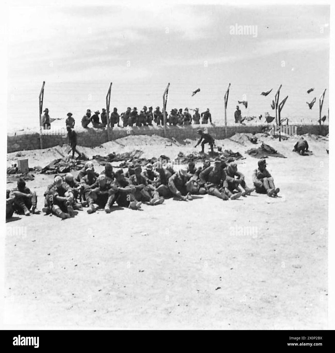 Deutsche Gefangene in einem Gefangenenlager der Westwüste werden von britischen und australischen Truppen beobachtet. Fotografisches negativ, britische Armee. Stockfoto