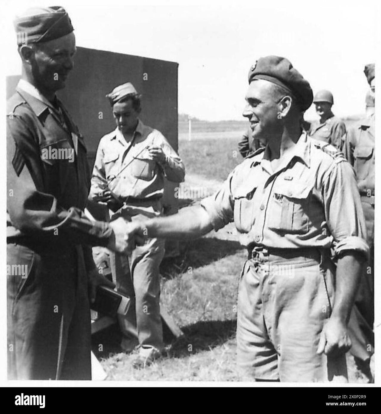 Sgt. Johnson erhält die Ehrenmedaille und gratuliert Sgt. F. Thomas vom 75. Hochland-Heavy-Regiment, Royal Artillery, der die 5. Armee unterstützt. Stockfoto