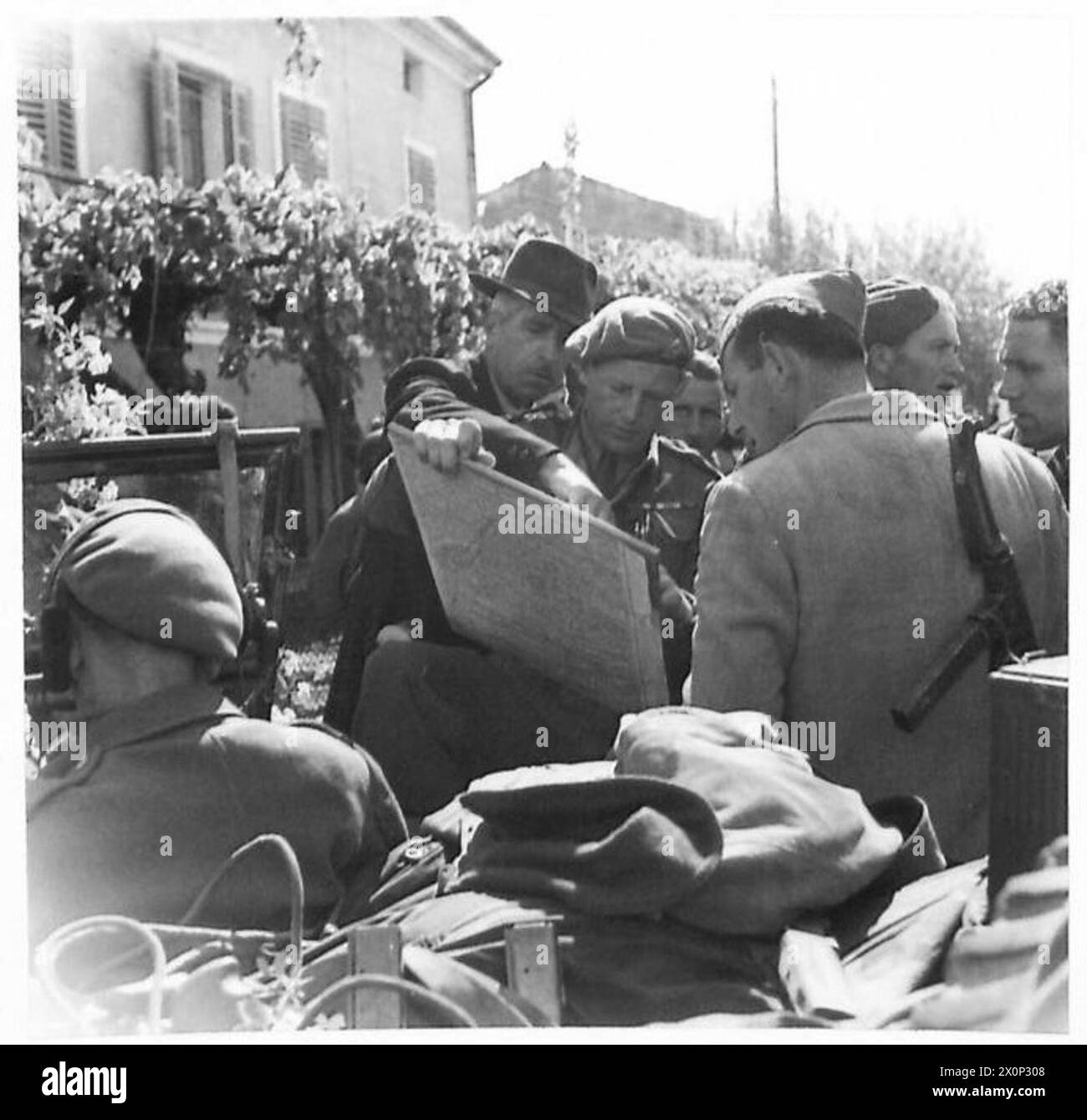 Ein Partisanen identifiziert feindliche Positionen auf einer Karte, die von einem neuseeländischen Offizier während des Vormarsches der Achten Armee nach Triest gehalten wurde. Fotografisches negativ der britischen Armee. Stockfoto