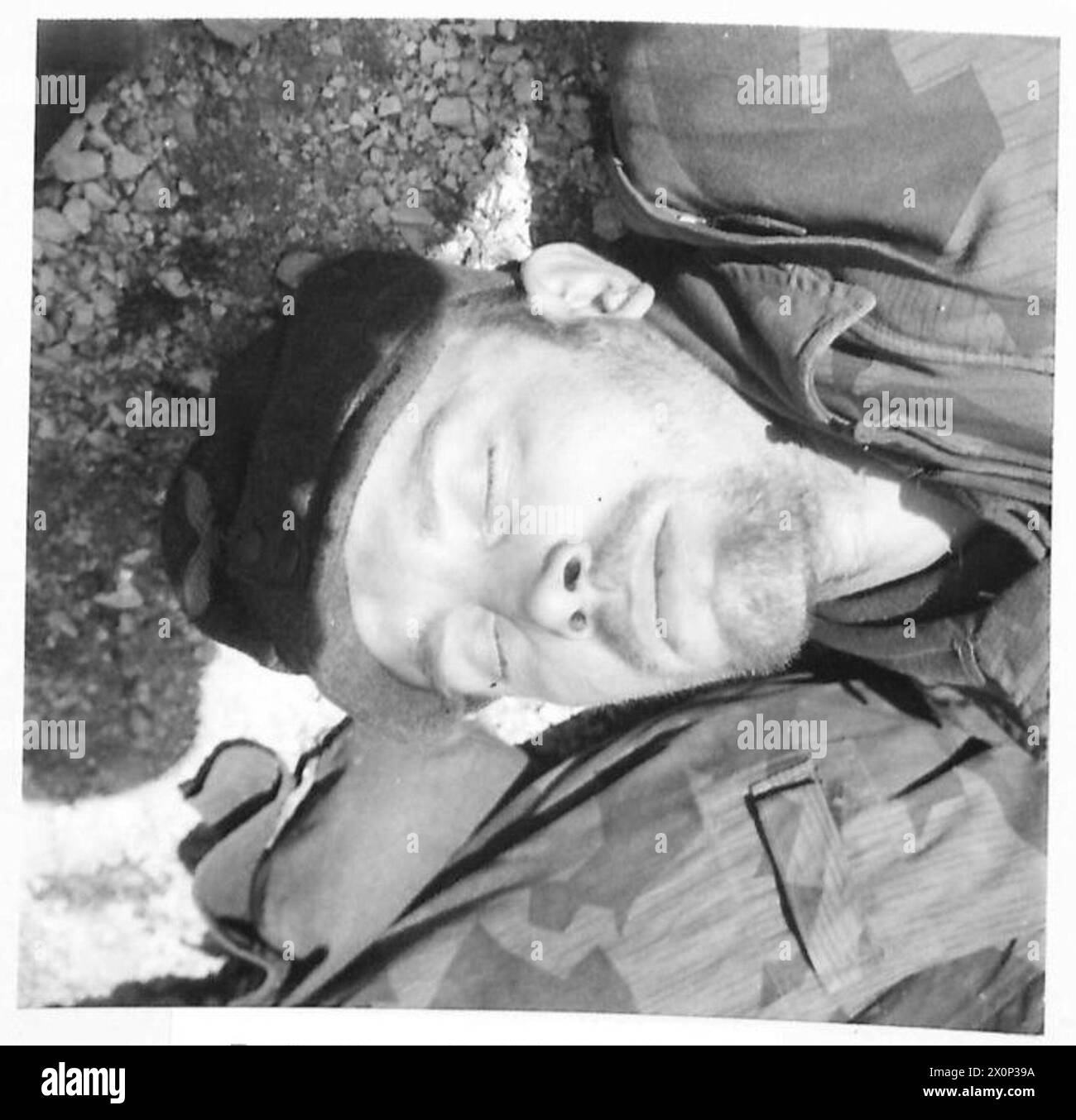 FÜNFTE ARMEE: CASSINO FRONTPARATROOP GEFANGENE AUS CASSINO - Ein deutscher Panzergrenadier, unrasiert, müde nach stundenlangem Zuschauen und Warten auf einen alliierten Angriff, schläft unwissend auf seine Umgebung an einem alliierten P.O.W. Sammelpunkt. Fotografisches negativ, britische Armee Stockfoto