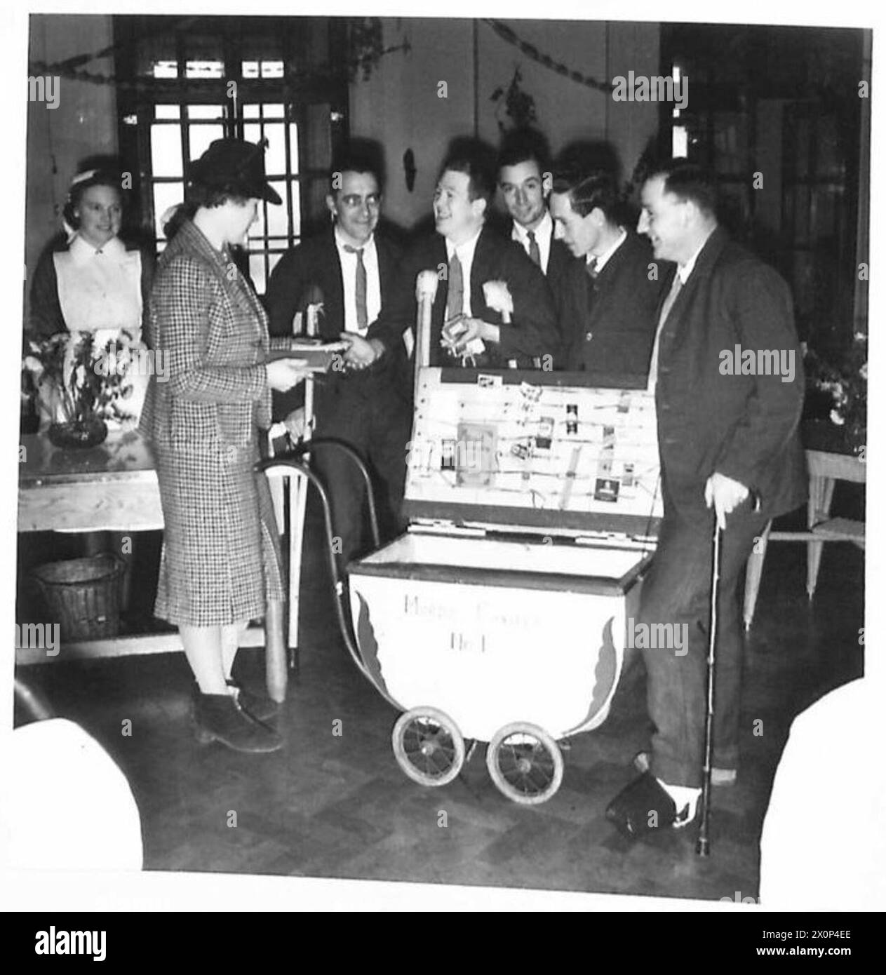 Fotografisches negativ, das Mrs. Gordon Johnson zeigt, wie sie Komfortartikel an Patienten aus einem mobilen Geschäft in einem Krankenhaus in Nordirland verkauft. Stockfoto