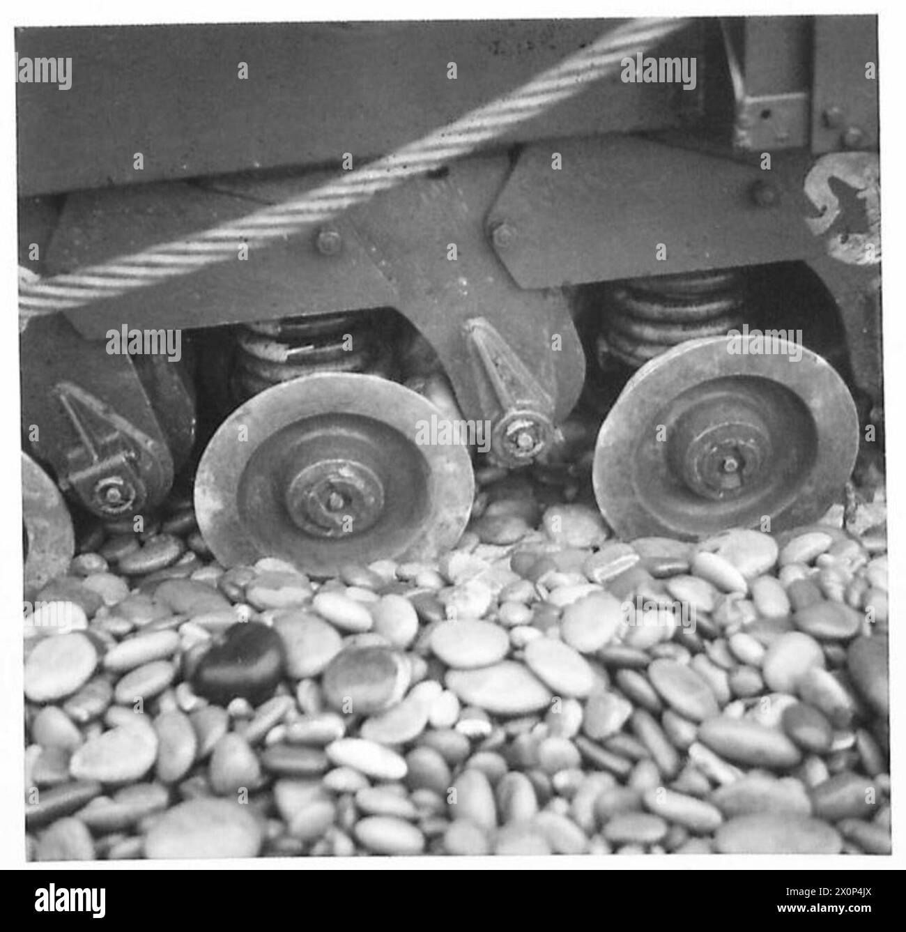 Die rechte Seite eines normalen Tanks zeigt Steine, die Drehgestelle blockieren, nachdem sie sich über 50 Meter Schindel bewegt haben. Stockfoto